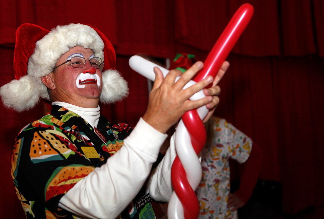 A clown at the Marine Corps Base Camp Lejeune Headquarters and Support Battalion Holiday Jubilee makes a candy cane balloon for a child at the Goettge Field House Dec. 6. The jubilee started at 5 p.m., and featured two magicians and a raffle, along with dinner.