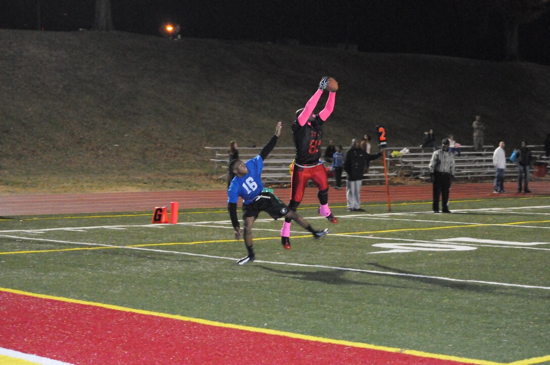 Joe Randall, offensive captain for Manpower and Reserve Affairs' American League intramural flag football team, stretches pass an opposing defender to complete a pass during the championship game at Butler Stadium on Dec. 10.