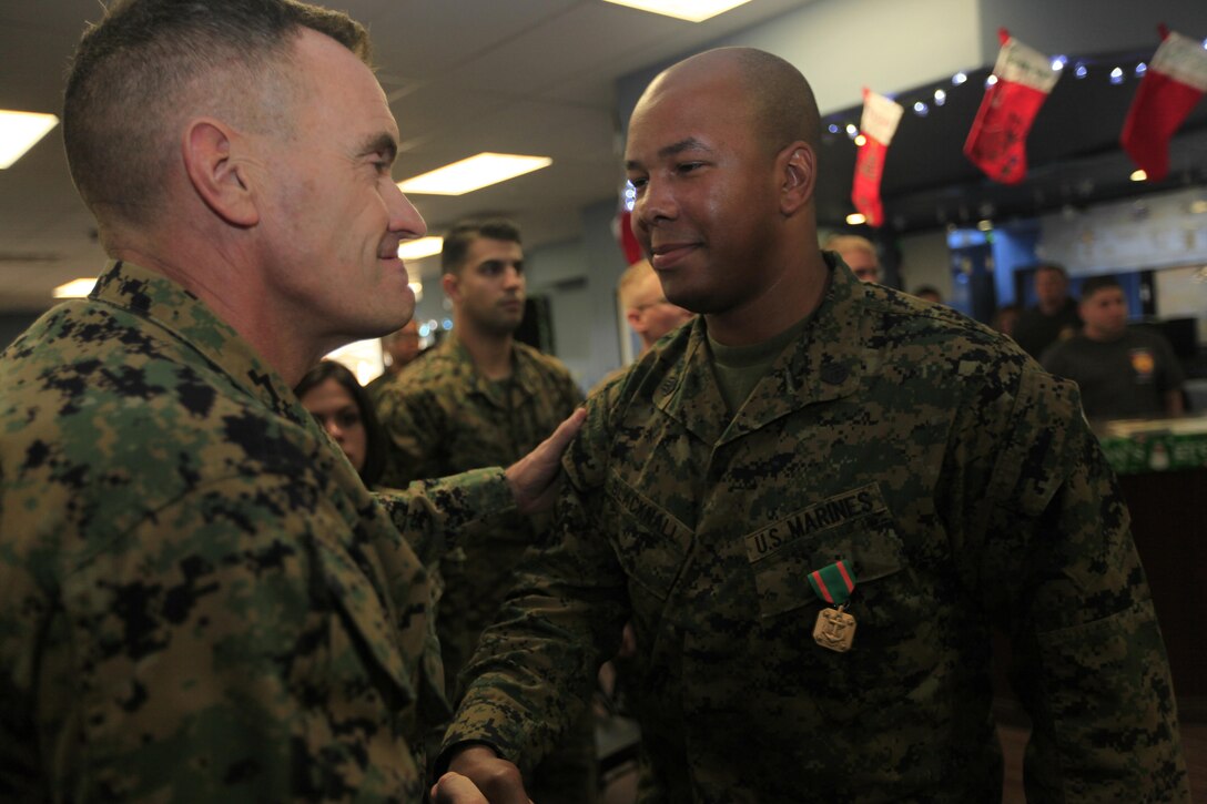 Brig. Gen. Vincent A. Coglianese, left,  congratulates Staff Sgt. Jamal K. Blacknall here Dec. 6 after presenting the staff sergeant with a Navy Achievement Medal and a plaque for his service in various positions in the base’s Single Marine Program. Blacknall serves as a radio technician with the 11th Marine Regiment here. Coglianese is the base commanding general and regional authority for five military installations in the Southwestern United States.