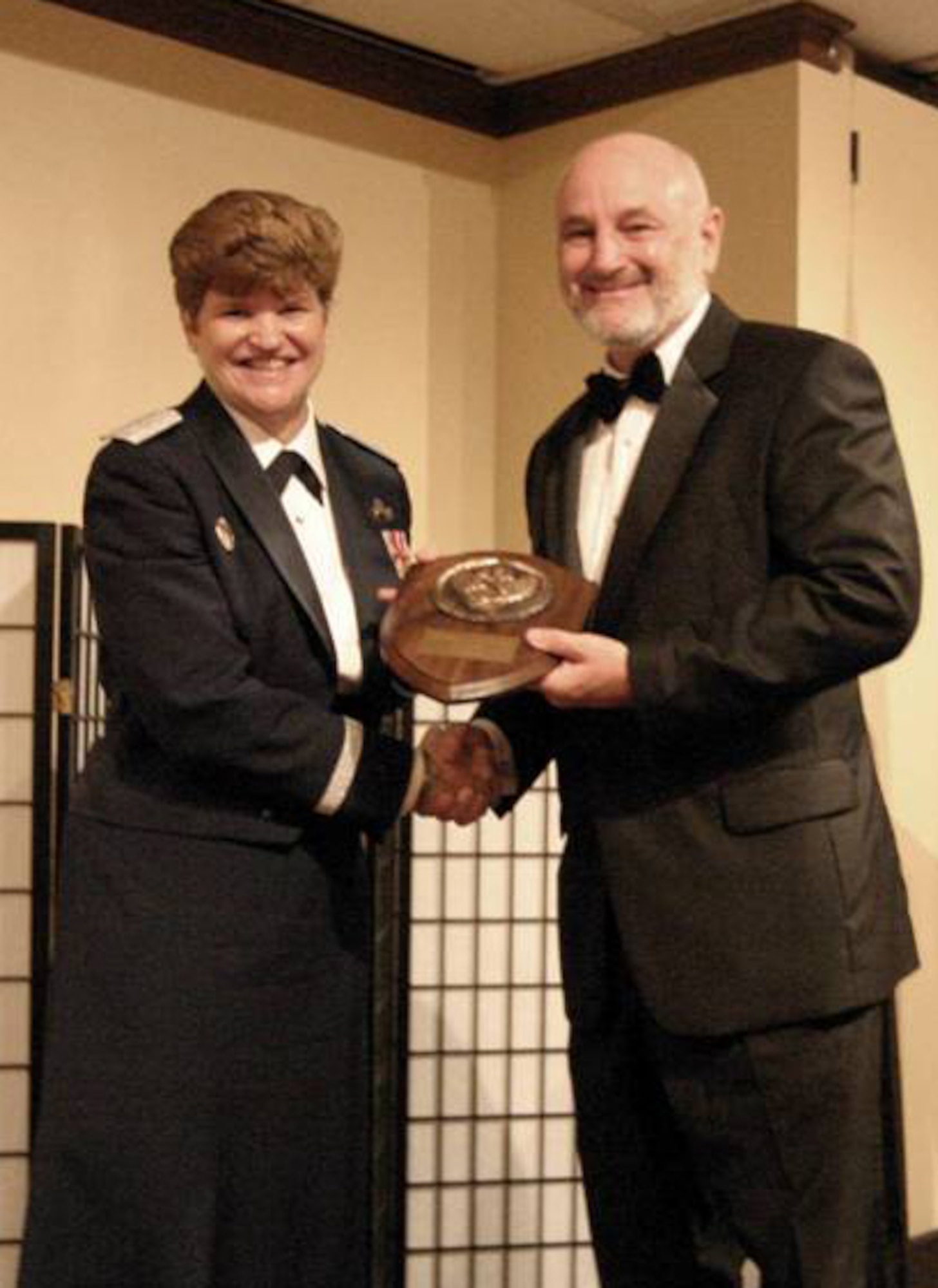 Dave Madden, MILSATCOM director receives a plaque from Gen. Janet Wolfenbarger, Air Force Material Command commander, upon his induction into the Space Operations Hall of Fame, Nov. 3. (Photo provided by the San Jose Chapter of the AFA)