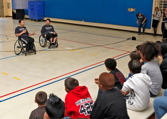 Domonic Corrabin (left), Triumph Foundation ambassador, and Andrew Skinner, Triumph Foundation director, speak to a group of the Edwards youth at the Youth Center Gym Dec. 6, 2012 during an adapted sports clinic hosted by the Youth Center and the Triumph Foundation. The clinic was held in order to bring awareness to the Edwards community about adapted sports. (U.S. Air Force by Jet Fabara)