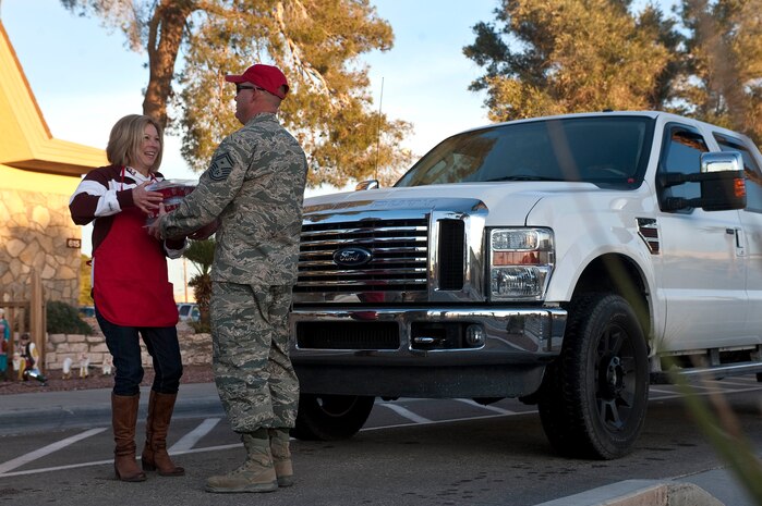 Stella Buck, senior-leader spouse, collects cookies for the Cookie Drive Dec. 11, 2012, at Nellis Air Force Base, Nev. Cookies are collected for the drive to be handed out to Airmen who live in the dormitories. (U.S. Air Force photo by Staff Sgt. Christopher Hubenthal)
