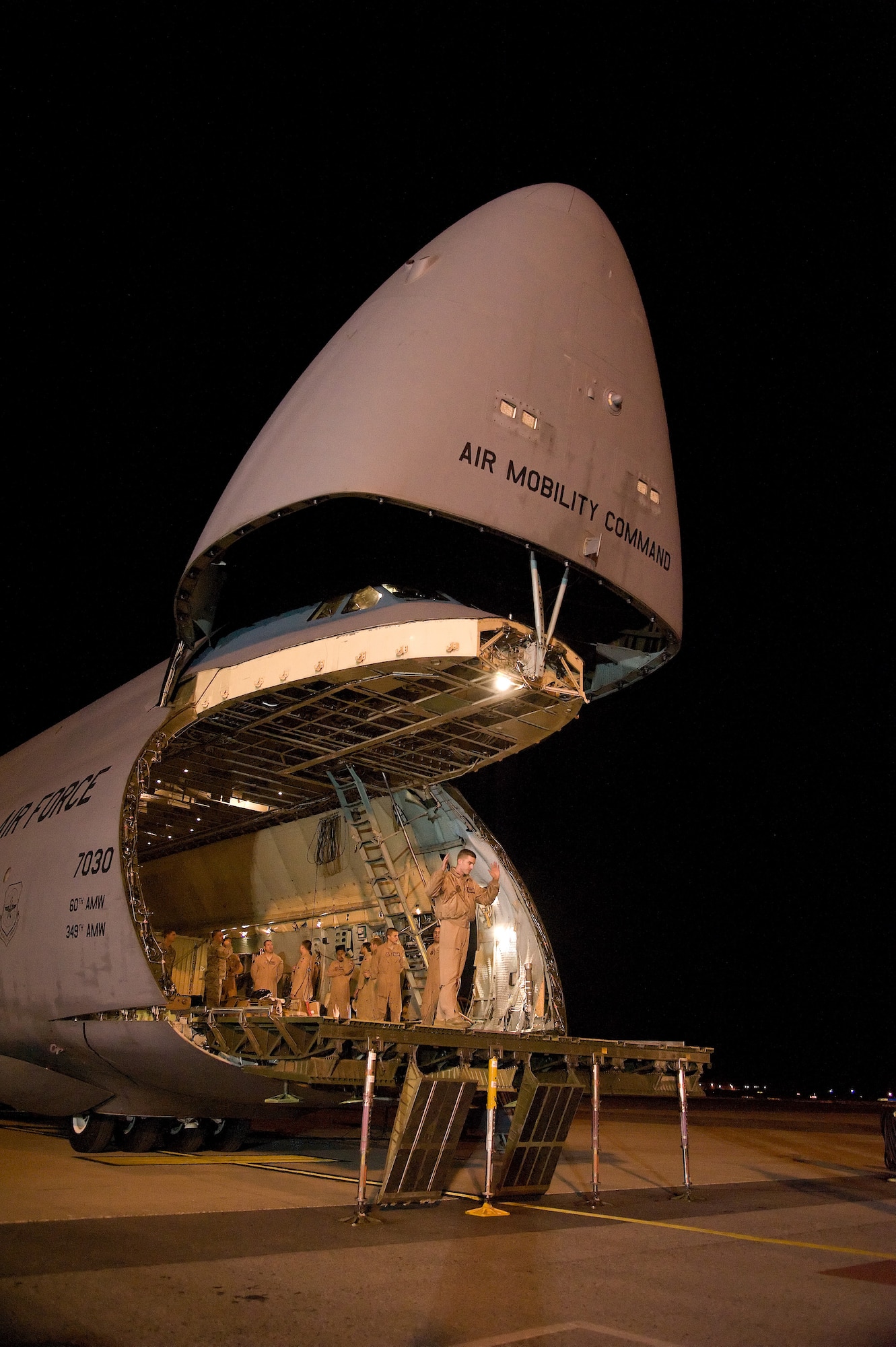 A loadmaster of a United States Air Force C-5 Galaxy of the 60th Air Mobility Wing, Travis AFB, Calif., signals to a cargo loader (not shown) being moved in to position Dec. 4, 2012, at Dover AFB, Del. The massive C-5 Galaxy aircraft has just completed a mission in support of Operation Enduring Freedom.  (U.S. Air Force photo by Greg L. Davis)