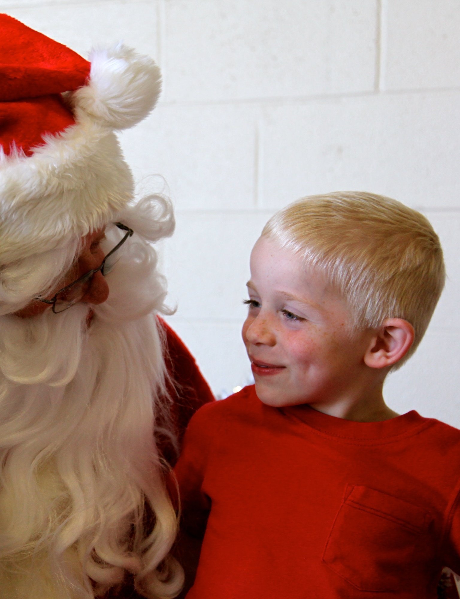 Logan Schumacher, son of Blain Schumacher 20th Civil Engineer Squadron assistant fire chief, whispers to Santa what he wants for Christmas.  The 20th Mission Support Group hosted a children's holiday party Dec. 9 at the Shaw AFB fire department.