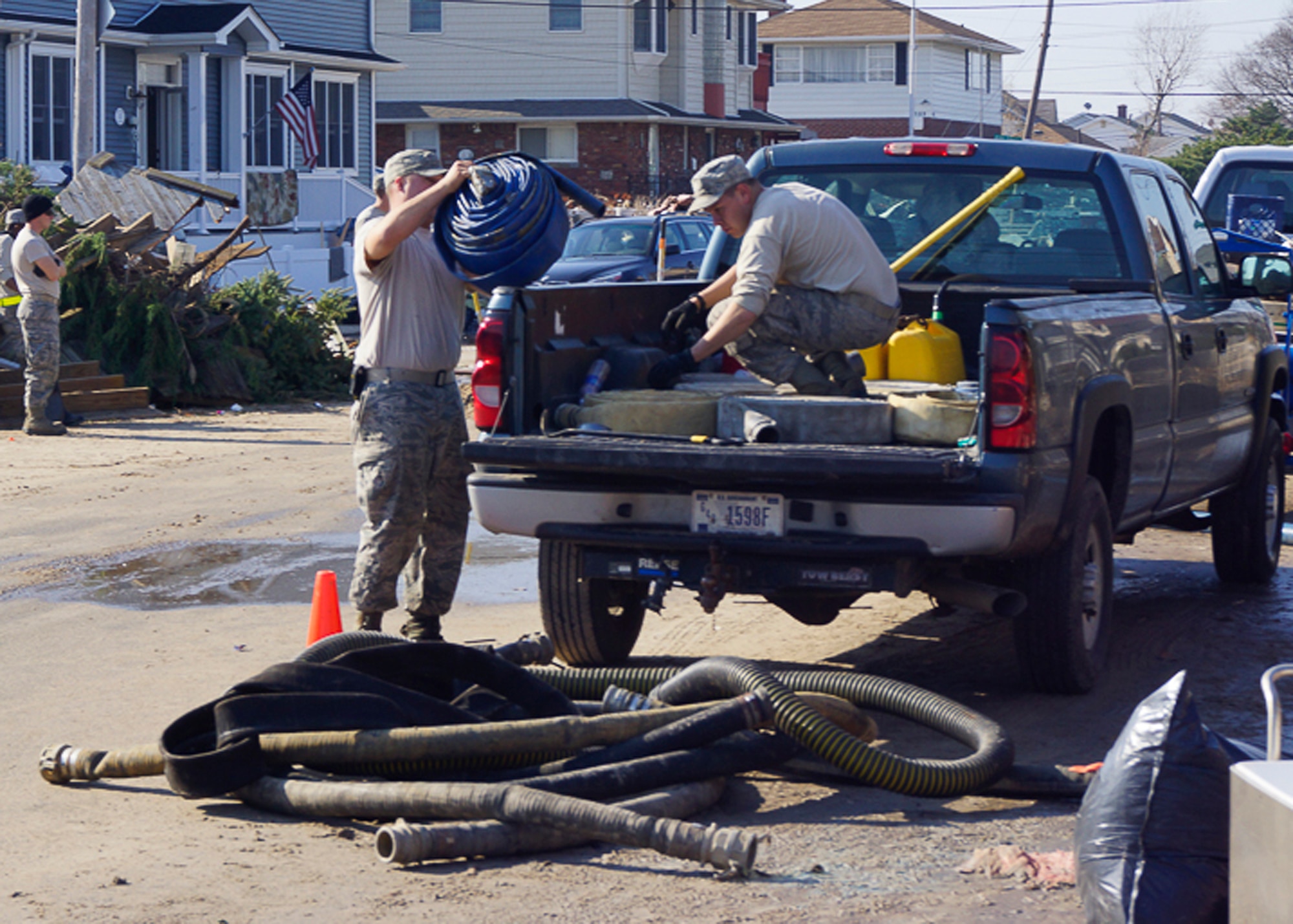Tech. Sgt. William Cox, 11th Civil Engineer Squadron water and fuel systems maintenance craftsman, and Senior Airman Matthew Rieman, 11th CES WFSM journeyman, unload pump hoses to run across the road Nov. 10, 2012 in Breezy Point, N.Y. The Joint Task Force included eight 11th CES Airmen with approximately 200 other Airmen, Sailors, Soldiers and Marines who deployed to assist with Hurricane Sandy relief efforts. (U.S. Air Force photo/Tech. Sgt. Eddie White)