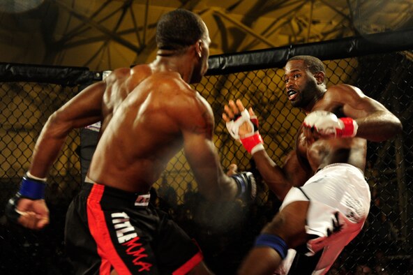 Staff Sgt. Steve Burks, an avionics Airman of 1st Special Operations Aircraft Maintenance Squadron, evades strikes from his opponent, Michael Roberts, in the co-main event at Strike Fight at Hanger 102 at Eglin Air Force Base, Fla., Dec. 8.  The match lasted three, five-minute rounds filled with striking, wrestling and jiu-jitsu. (U.S. Air Force Photo / Airman 1st Class Benjamin D. Kim)