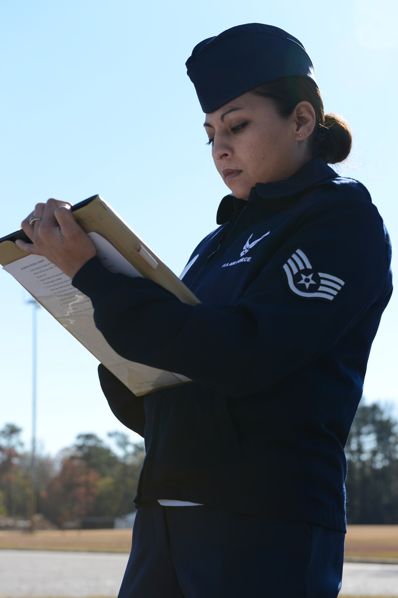 Staff Sgt. Julie Walker, U.S Air Forces Central Command postal operations manager, scores an Air Force Junior ROTC drill team during a drill competition at Sumter High School, S.C., Nov. 29, 2012. Walker and four other Airmen from Shaw Air Force Base, S.C., volunteered to judge the competition. (U.S. Air Force photo by Airman 1st Class Krystal M. Jeffers/Released)