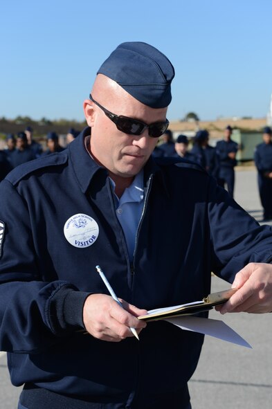 Master Sgt. Thomas Kime, 20th Logistics Readiness Squadron section chief of fuels distribution, scores an Air Force Junior ROTC drill team during a drill competition at Sumter High School, S.C., Nov. 29, 2012. After the competition, Kime and the four other volunteer judges from Shaw Air Force Base, S.C., spoke to each flight about being in the military. (U.S. Air Force photo by Airman 1st Class Krystal M. Jeffers/Released)