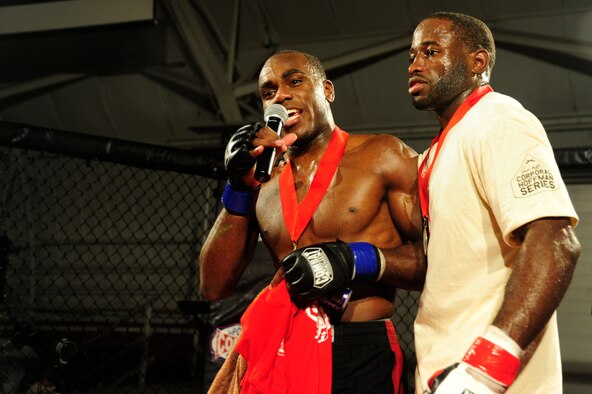 Staff Sgt. Steve Burks, an avionics Airman of 1st Special Operations Aircraft Maintenance Squadron, and his opponent, Michael Roberts, addresses the crowd after the fight in the co-main event at Strike Fight at Hanger 102 at Eglin Air Force Base, Fla., Dec. 8.  The two thanked the crowd and acknowledged their training teams and gyms.  (U.S. Air Force Photo / Airman 1st Class Benjamin D. Kim)