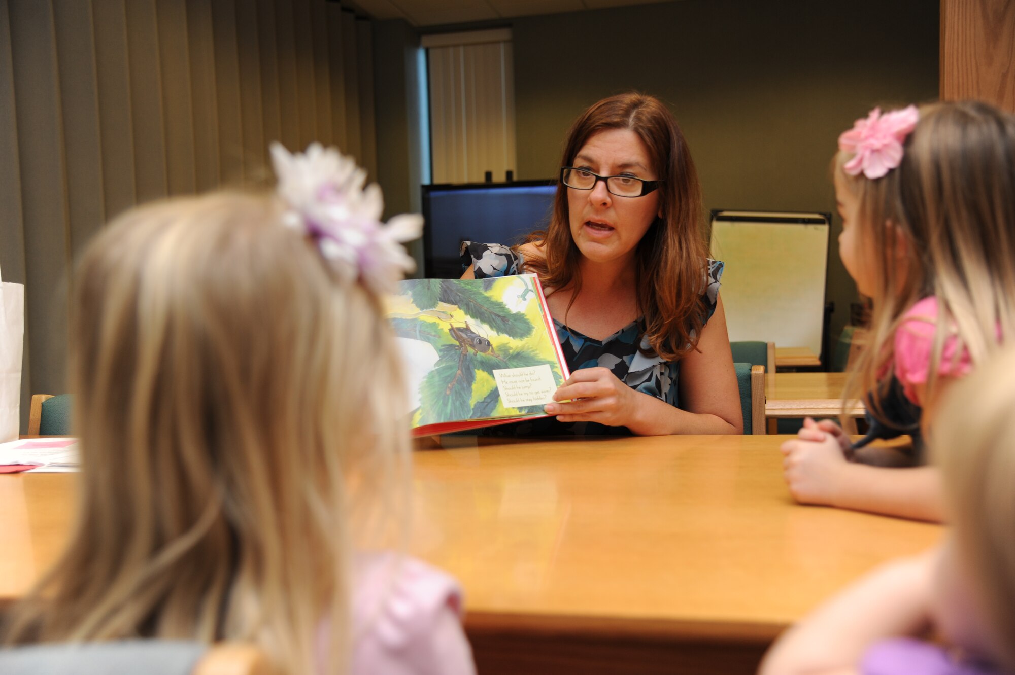 Kim Perez, a contractor with Families OverComing Under Stress, reads the book, ‘The Christmas Cricket’ by Eve Bunting, during story time at the McBride Library Dec. 6, 2012, Keesler Air Force Base, Miss.  FOCUS leads resiliency training for military families.  (U.S. Air Force photo by Kemberly Groue)