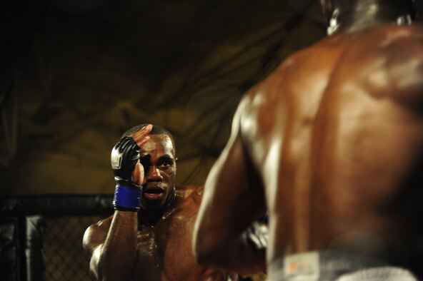 Michael Roberts covers his face as Staff Sgt. Steve Burks, an avionics Airman of 1st Special Operations Aircraft Maintenance Squadron, dances around him in an attempt to land a significant strike in the co-main event at Strike Fight at Hanger 102 at Eglin Air Force Base, Fla., Dec. 8.  The two men began opening up with strikes in later rounds as both relaxed and found their rhythm.  (U.S. Air Force Photo / Airman 1st Class Benjamin D. Kim)