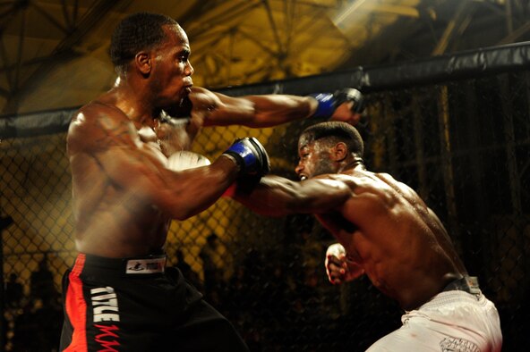 Staff Sgt. Steve Burks, an avionics Airman of 1st Special Operations Aircraft Maintenance Squadron, utilizes his left jab against his opponent, Michael Roberts, in an attempt to set up his take-down in the co-main event at Strike Fight at Hanger 102 at Eglin Air Force Base, Fla., Dec. 8. Roberts quickly countered with strikes of his own in later rounds as he found his rhythm and gained confidence. (U.S. Air Force Photo / Airman 1st Class Benjamin D. Kim) 

