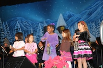 Children from the audience play musical instruments during the Holiday in Blue concert performed by the Band of the West Dec. 7 at the Edgewood Independent School District Theatre of Performing Arts in San Antonio.  The Band of the West provides hundreds of performances to military and civilian audiences throughout the year.(U.S. Air Force photo by Joel Martinez)