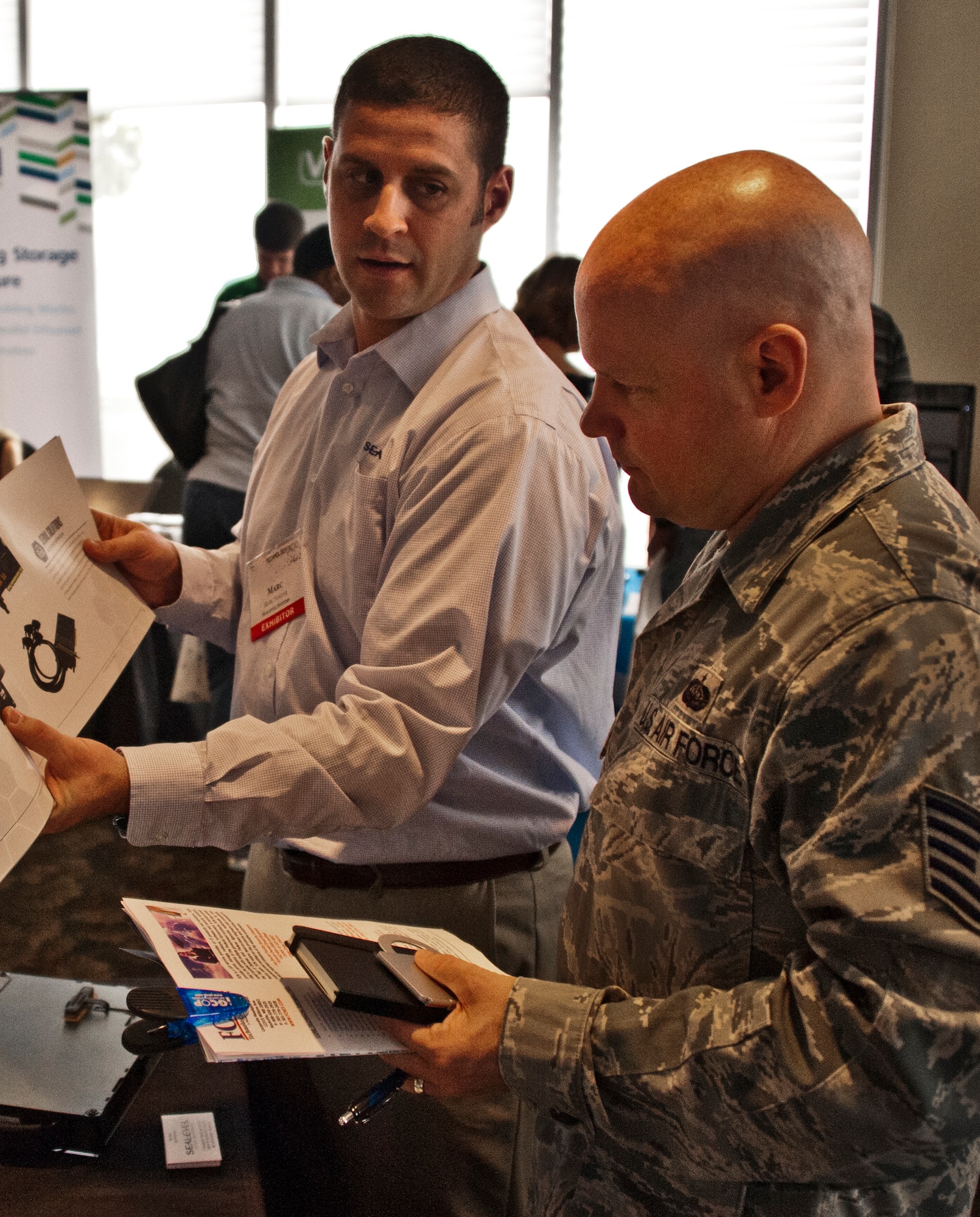 Tech. Sgt. Paul Bilpuch, of the 96th Communication Squadron, speaks to a Sealevel Systems specialist during a technology expo at the Bayview Club hosted by Eglin Air Force Base Dec. 10. The event provided a venue for Team Eglin members to see demonstrations of immerging technologies that are adaptable to their current duties and ever-changing work environment. (U.S. Air Force photo/Randy Gon)