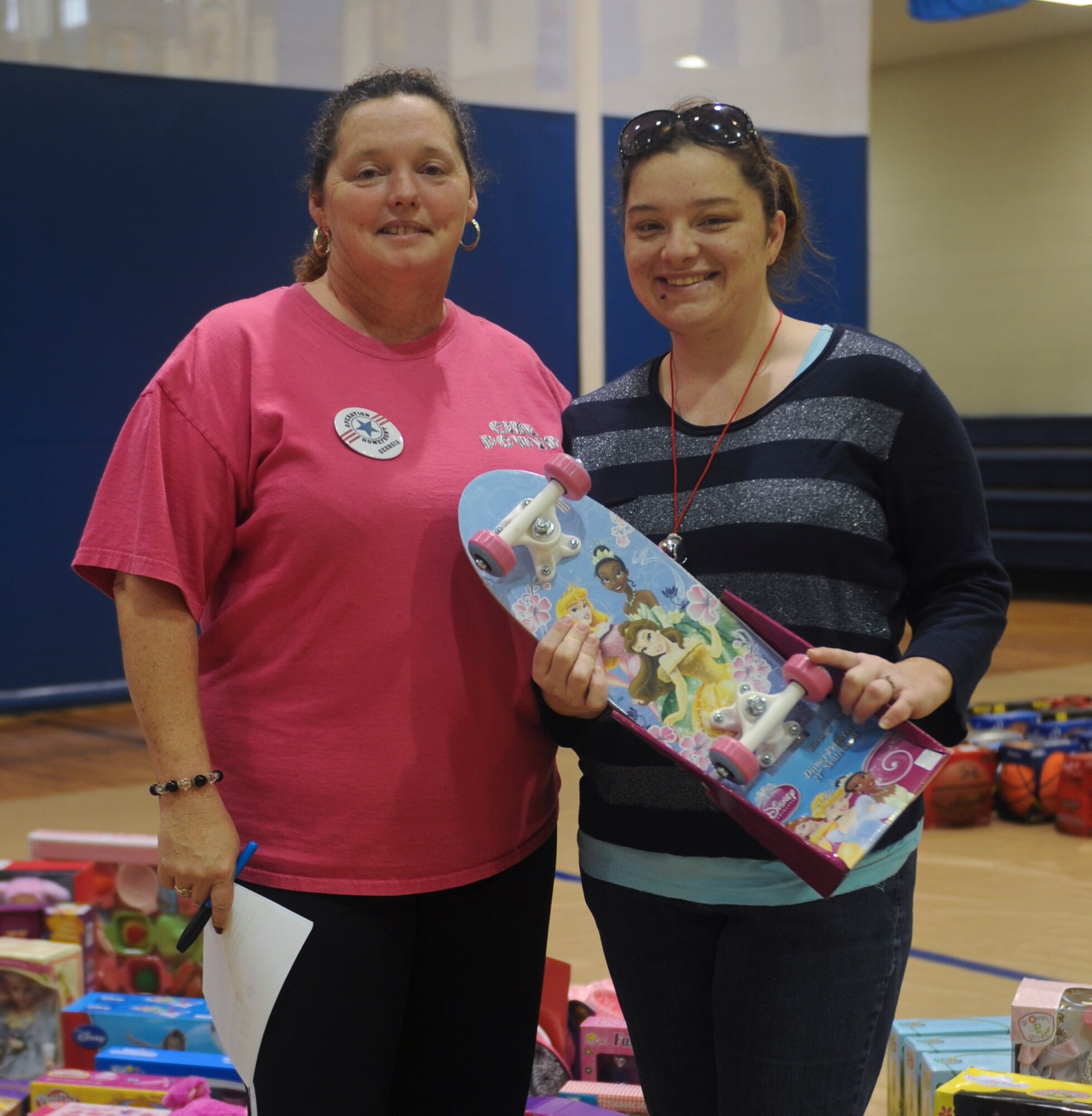Windy Scott, 23d Force Support Squadron exceptional family member program coordinator, assists Tiffany Cowen pick out toys during the Operation Homefront program at Moody Air Force Base, Ga., Dec. 8, 2012. The Airman and Family Readiness Center created a simulated toy store hosted by Operation Homefront for selected families from Moody. (U.S. Air Force photo by Airman 1st Class Olivia Bumpers/Released)