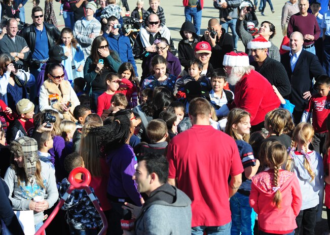Santa Claus is surrounded by youths after exiting a U-2 Dragon Lady at the Children's Holiday Party Dec. 8, 2012, at Beale Air Force Base, Calif. Santa and event organizers distributed more than 1,500 gifts donated by Toys for Troops. (U.S. Air Force photo by Senior Airman Shawn Nickel/Released)