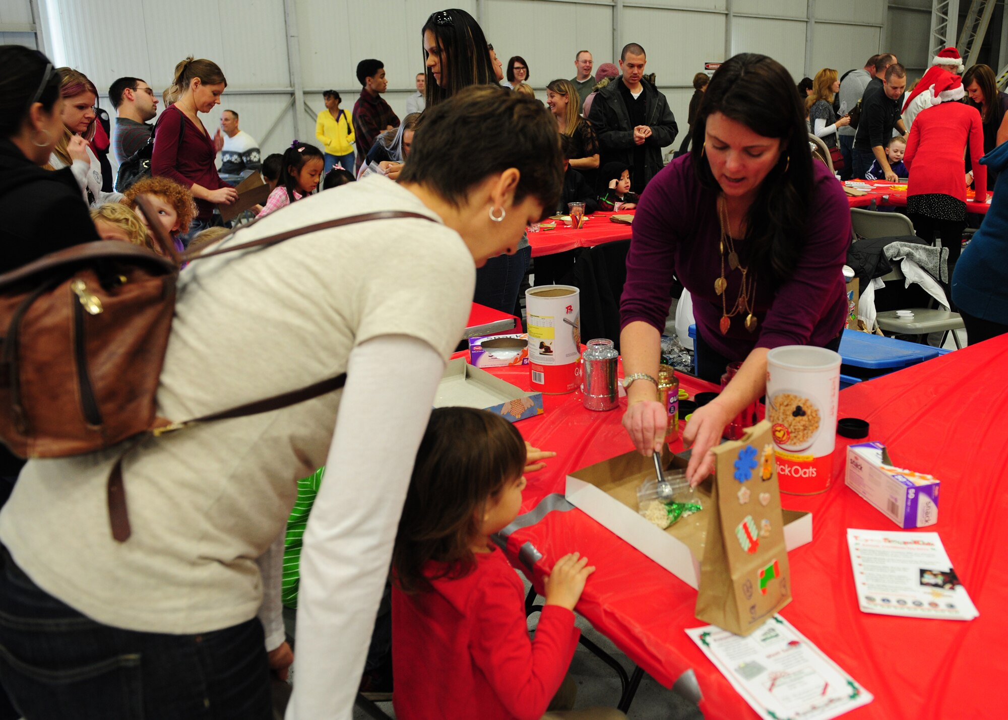 Volunteers from Beale’s Enlisted Spouses Club help with crafts during the Children’s Holiday Party at Beale Air Force Base, Calif., Dec. 8, 2012. More than 75 volunteers from Beale and the surrounding community provided face painting, pictures, crafts and food while the Wheatland High School Band played holiday music throughout the event. (U.S. Air Force photo by Senior Airman Shawn Nickel/Released)
