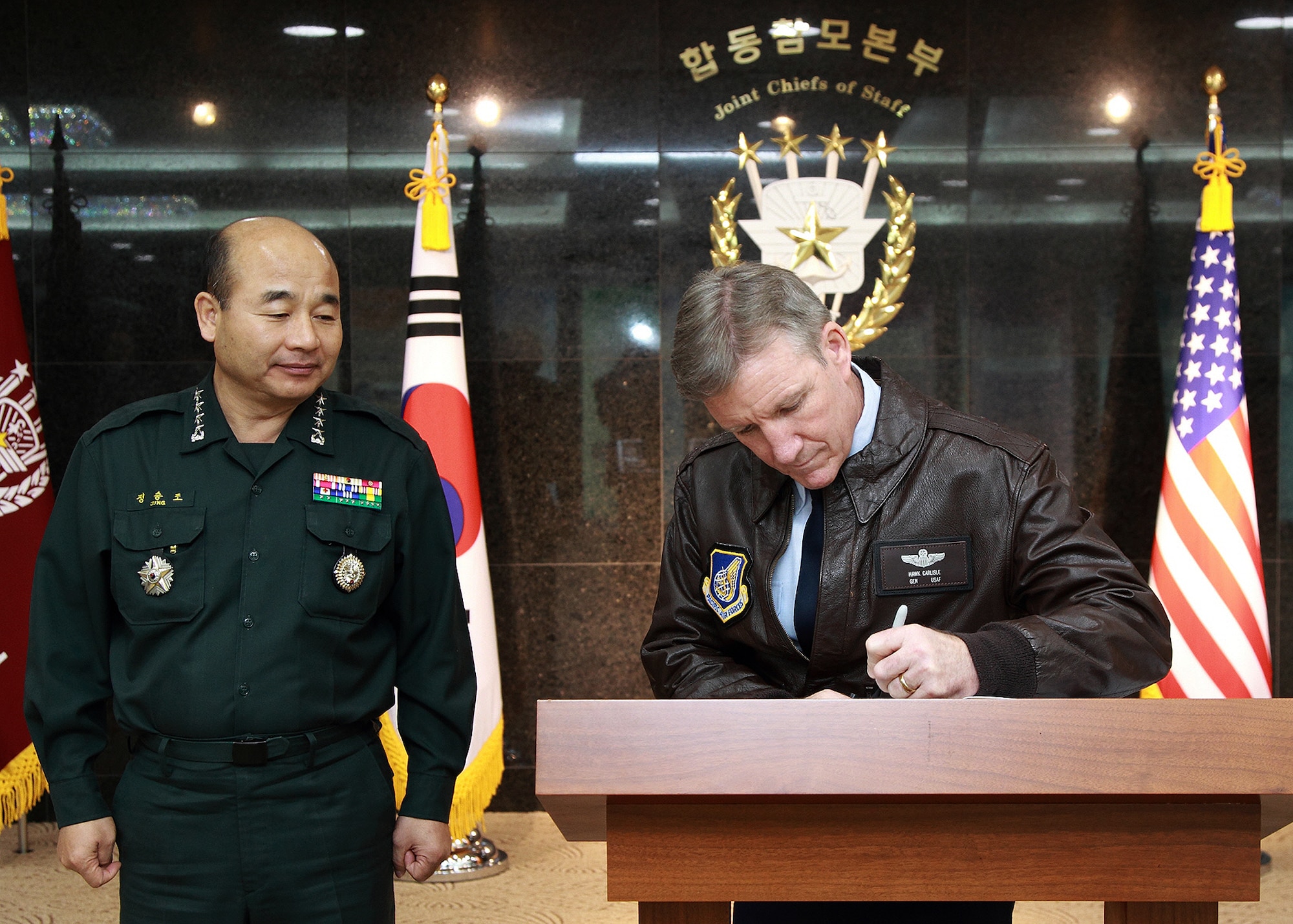 Gen. Herbert “Hawk” Carlisle, Pacific Air Forces commander, signs the Republic of Korea Joint Chiefs of Staff headquarters’ distinguished visitors book, as ROK Chairman of the Joints Chiefs, Gen. Seung-jo Jung, looks on at Daejeon, South Korea, Nov. 30, 2012.  Carlisle visited the peninsula to meet with ROK senior officials and to discuss mutual interests in the region. (Courtesy photo)