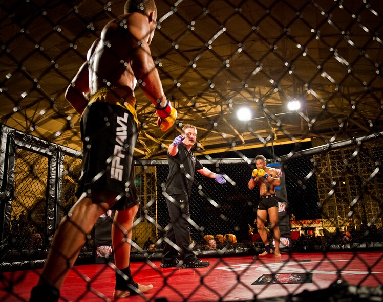 Wesley Barnes (far right) stares down Dan Martinez as their mixed martial arts bout begins at the Strike Fight event Dec. 8 at Eglin Air Force Base, Fla.  Barnes won a unanimous decision over Martinez in one of 11 matches held at the base’s first-ever MMA event that drew approximately 775 people.  (U.S. Air Force photo/Samuel King Jr.)