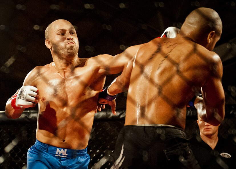 Danny Ruiz backs up William “The Slim Reaper” Kuhn with a punch during the mixed martial arts main event at Strike Fight Dec. 8 at Eglin Air Force Base, Fla.  Ruiz, an Air Force Reserve staff sergeant with the 919th Special Operations Wing, won by unanimous decision in one of 11 matches held at the base’s first-ever MMA event.  The debut event drew approximately 775 people.  (U.S. Air Force photo/Samuel King Jr.)