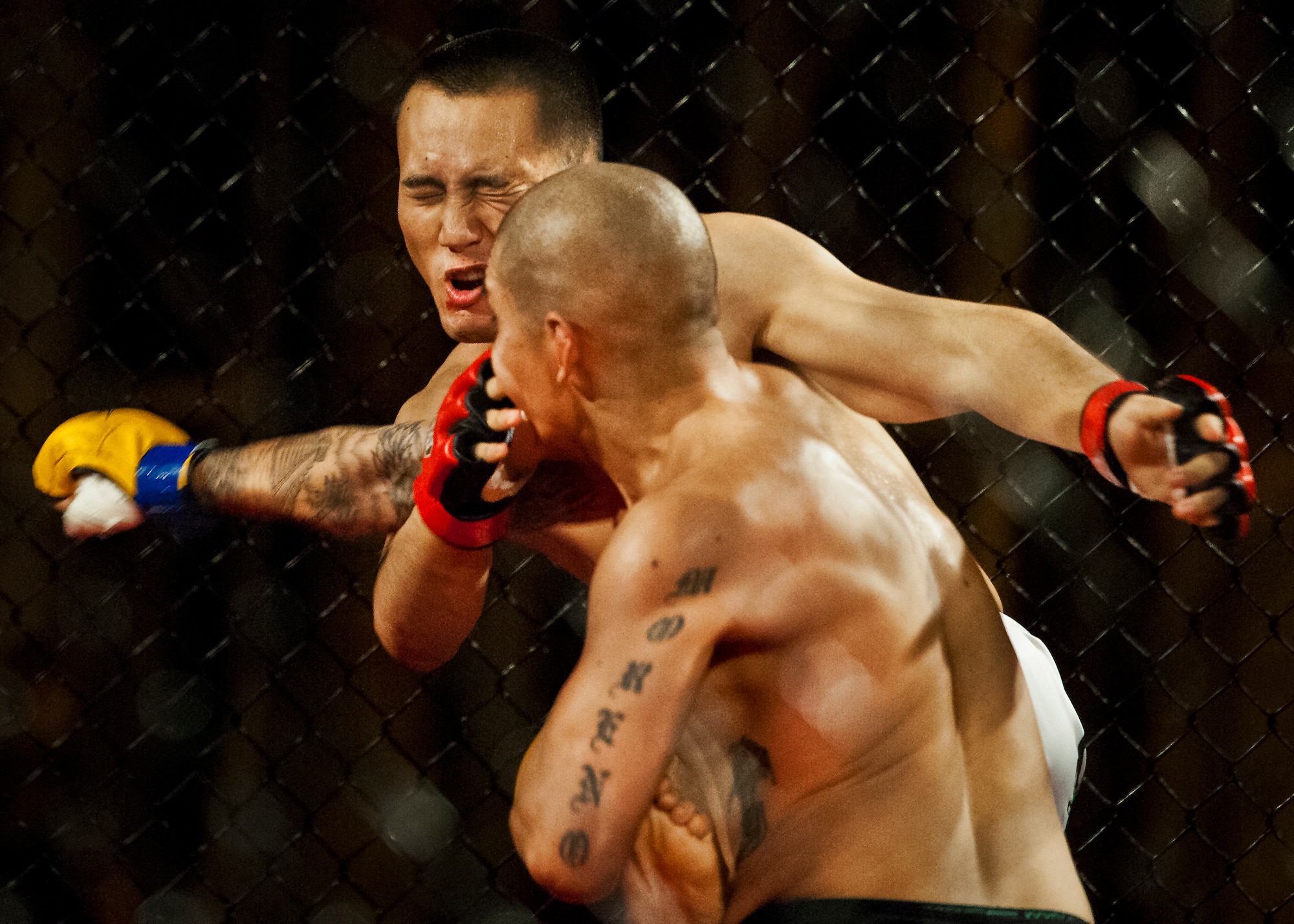 Isaac Moreno punches Henry Liu in the face during their mixed martial arts bout at the Strike Fight event Dec. 8 at Eglin Air Force Base, Fla.  Moreno won by a technical knockout in one of 11 matches held at the base’s first-ever MMA event that drew approximately 775 people.  (U.S. Air Force photo/Samuel King Jr.)
