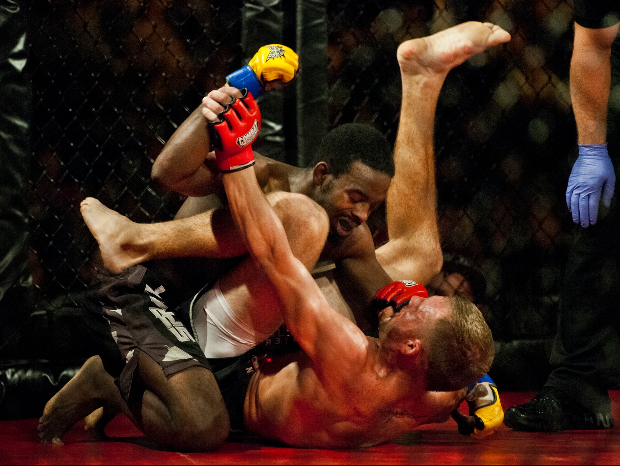 Robert Gillon (top) grapples with Chris Falasca during their mixed martial arts bout at the Strike Fight event Dec. 8 at Eglin Air Force Base, Fla.  Falasca won a split decision over Gillon in one of 11 matches held at the base’s first-ever MMA event that drew approximately 775 people.  (U.S. Air Force photo/Samuel King Jr.)