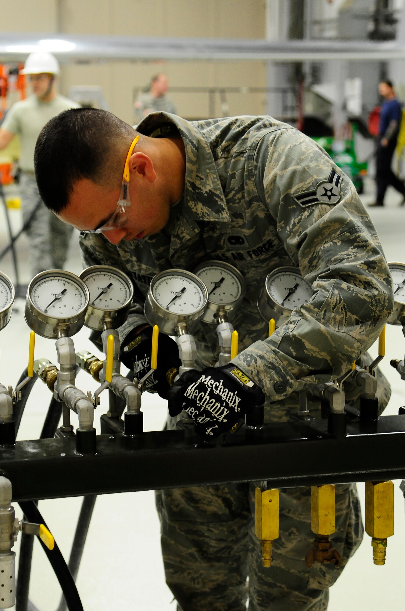 Airman 1st Class Anthony Hoffstatter, 86th Maintenance Squadron airframe reclamation, attaches hoses to a control consol for the aircraft lifting bags on Ramstein Air Base, Germany, Dec. 10, 2012. The aircraft lifting bags are used to lift an aircraft to make adjustments. (U.S. Air Force photo/Airman 1st Class Hailey Haux)