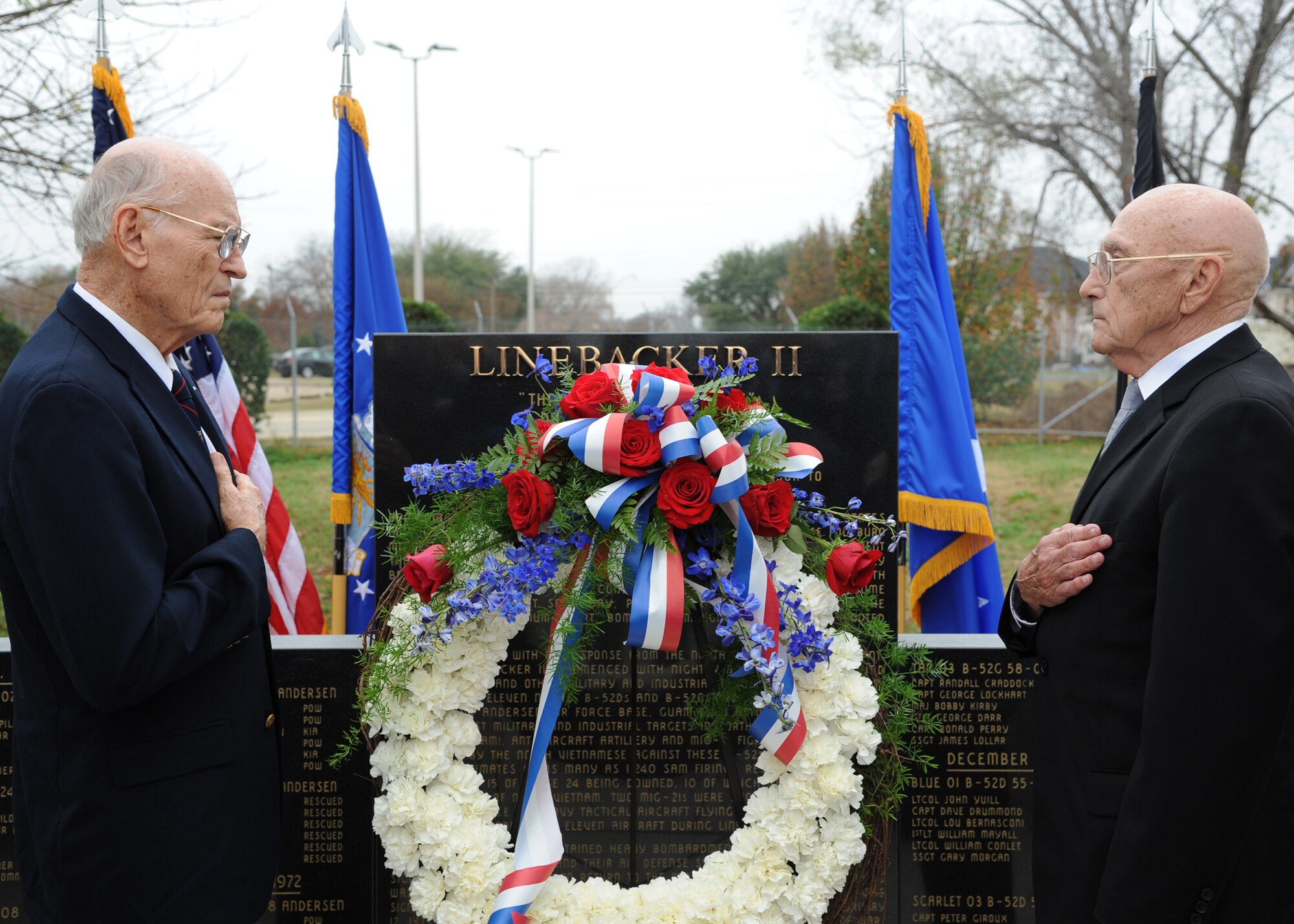 Brig. Gen. (Ret) James McCarthy and Maj. Gen. (Ret) Thomas Rew, both Linebacker II veterans, place their hands over their hearts during the playing of “Taps” on Barksdale Air force Base, La., Dec. 8. McCarthy and Rew assisted the base honor guard with presenting a wreath to commemorate Operation Linebacker II. (U.S. Air Force photo/Airman 1st Class Joseph A. Pagán Jr.)