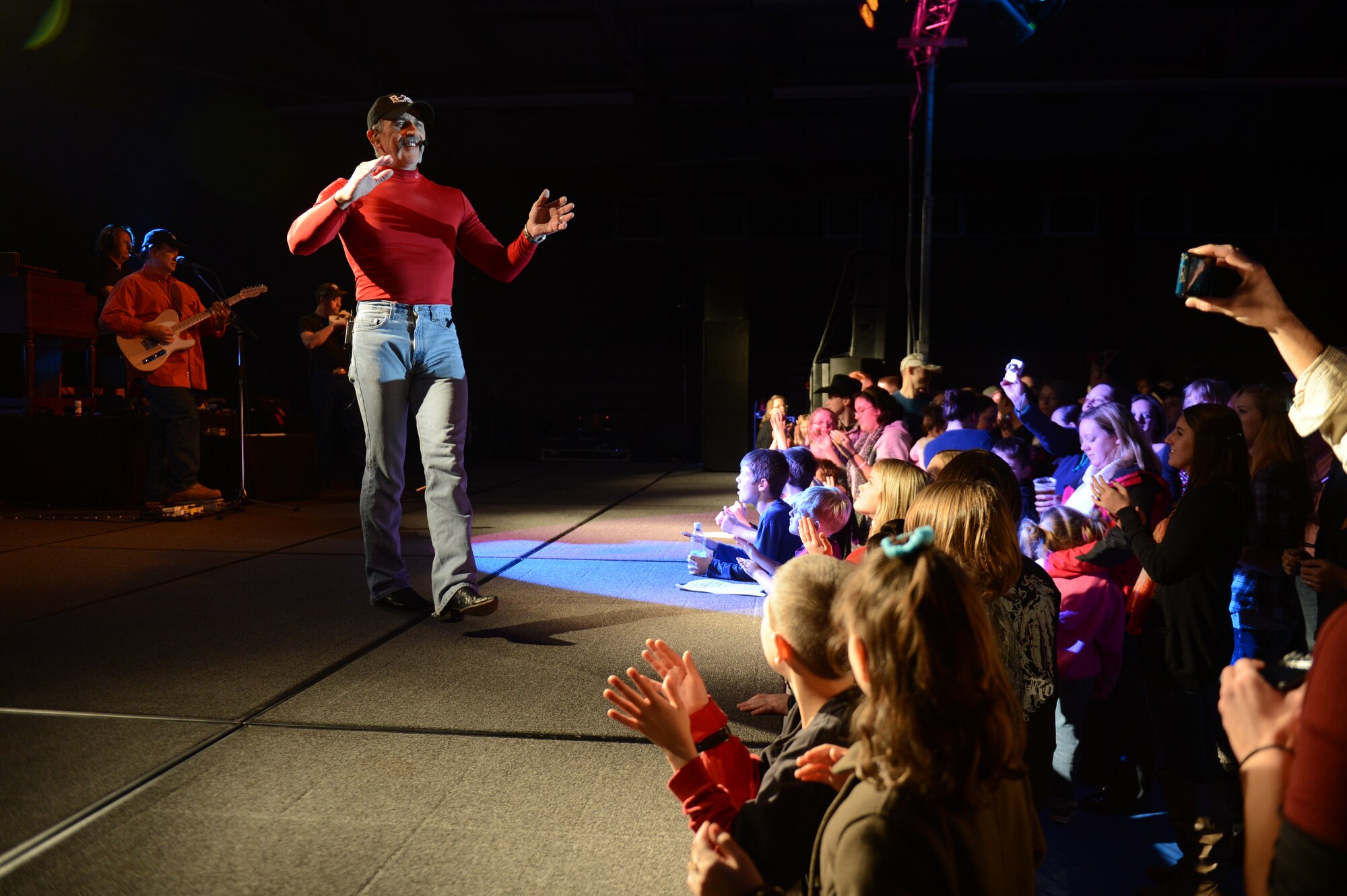 SPANGDAHLEM AIR BASE, Germany – Country music singer Aaron Tippin interacts with an audience on stage during a concert inside the Skelton Memorial Fitness Center Dec. 7, 2012. Armed Forces Entertainment, which is a program that hosts more than 1,200 shows around the world each year reaching more than 270 military installations, sponsored the tour. (U.S. Air Force photo by Airman 1st Class Gustavo Castillo/Released)
