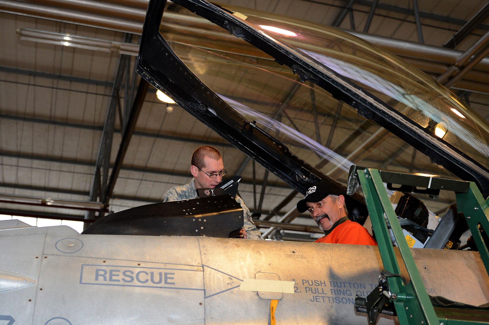 SPANGDAHLEM AIR BASE, Germany – U.S. Air Force Staff Sgt. Matthew Pugh, 52nd Equipment Maintenance Squadron F-16 Fighting Falcon fighter aircraft phase team member from Opelika, Ala., shows Aaron Tippin, country music singer, the inside of an F-16 cockpit during his tour of the base Dec. 7, 2012. Tippin toured some of the base’s facilities to meet with a broader range of Airmen and community members. (U.S. Air Force photo by Airman 1st Class Dillon Davis/Released)