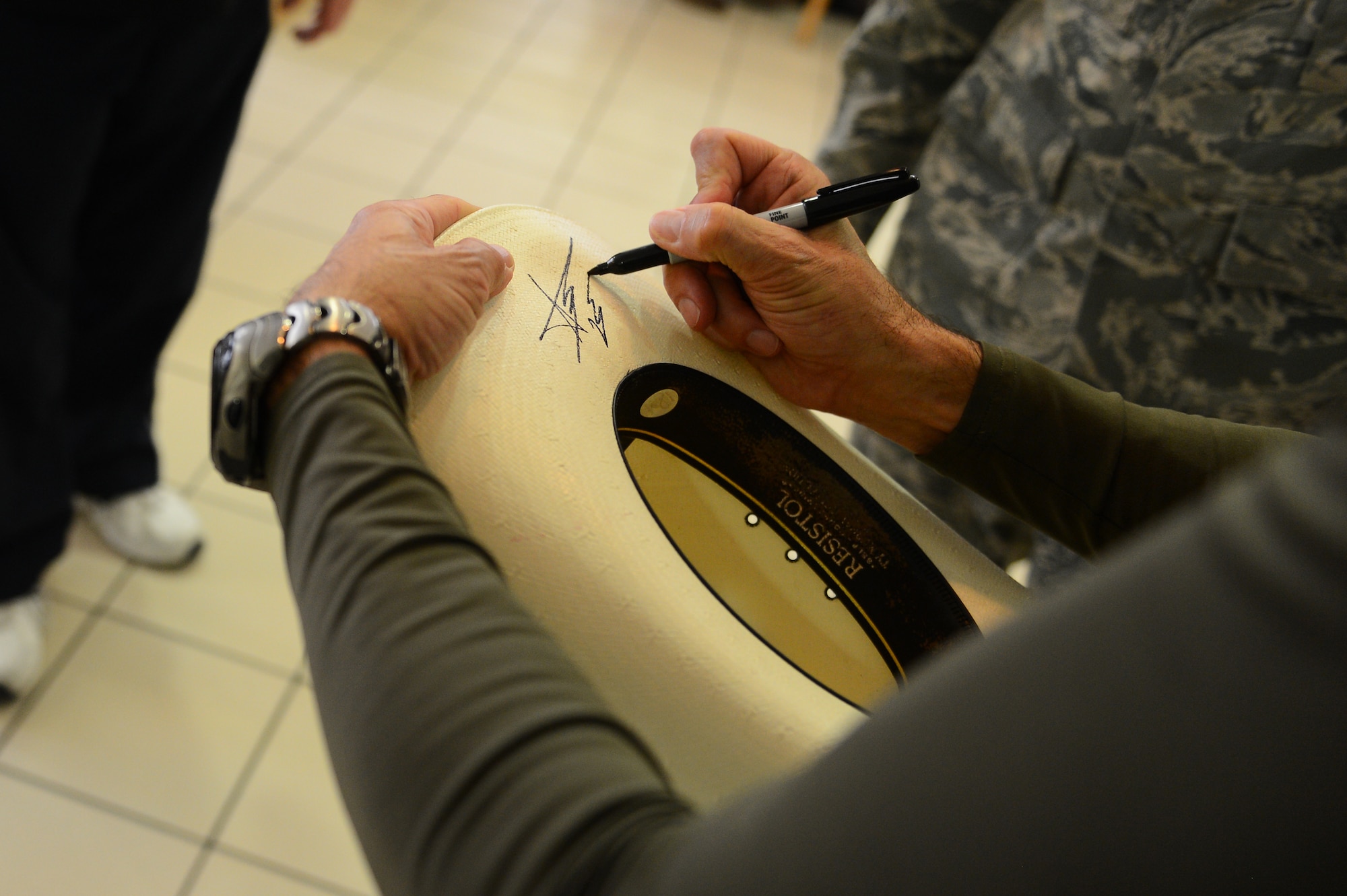 SPANGDAHLEM AIR BASE, Germany – Aaron Tippin, country music singer, signs an autograph for a fan during his visit to Spangdahlem AB Dec. 7, 2012. During his visit, he had lunch with 52nd Fighter Wing Airmen.Tippin made sure every Airman at the lunch was able to get an autograph. The Armed Forces Entertainment organization sets up celebrity visits and tours like this to provide entertainment to Airmen and their families. (U.S. Air Force photo by Airman 1st Class Dillon Davis/Released)
