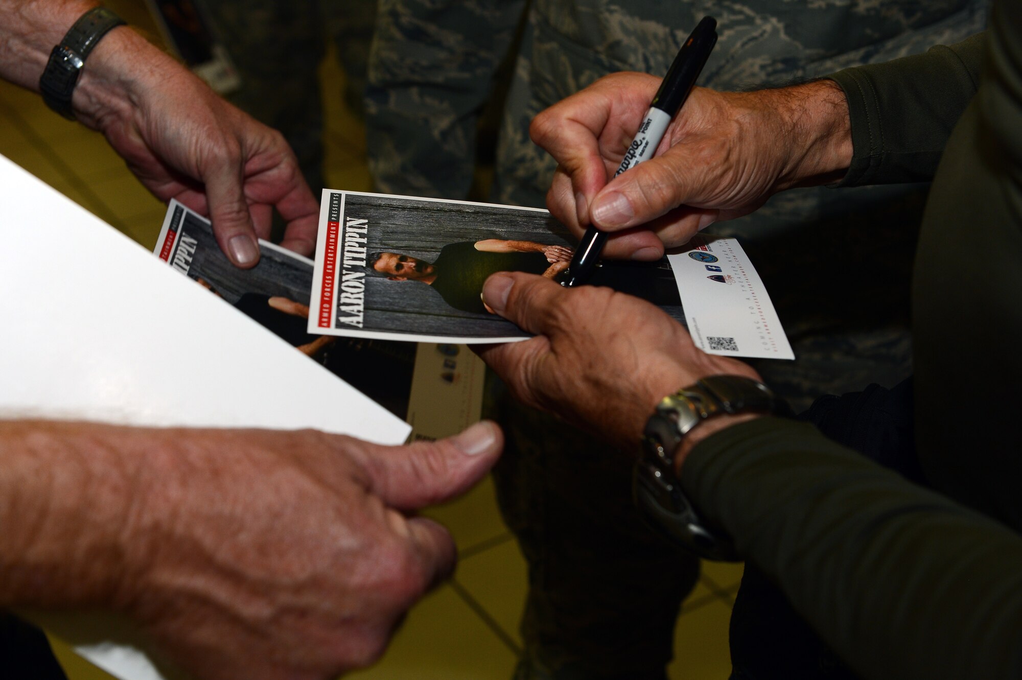 SPANGDAHLEM AIR BASE, Germany – Aaron Tippin, country music singer, signs an autograph for a fan during his visit to Spangdahlem AB Dec. 7, 2012. During his visit, he had lunch with 52nd Fighter Wing Airmen.Tippin made sure every Airman at the lunch was able to get an autograph. The Armed Forces Entertainment organization sets up celebrity visits and tours like this to provide entertainment to Airmen and their families. (U.S. Air Force photo by Airman 1st Class Dillon Davis/Released)
