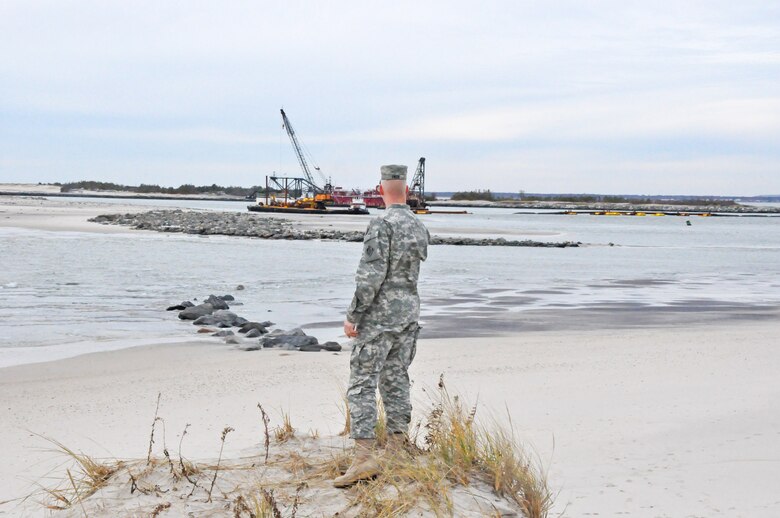 Col. Paul E. Owen, commander of the New York District of the U.S. Army Corps of Engineers stands on the edge of a dune in Cupsogue County Park on Friday November 16, 2012 on a barrier island in Long Island and looks over where Hurricane Sandy created a breach in the barrier island. In the distance is a dredge in nearby Moriches Inlet that is mobilizing to close the breach using sand from the inlet. The breach closure work is being done in partnership with the New York State Department of Environmental Conservation and local authorities in accordance with the Breach Contingency Plan. (photo by Chris Gardner, New York District public affairs)