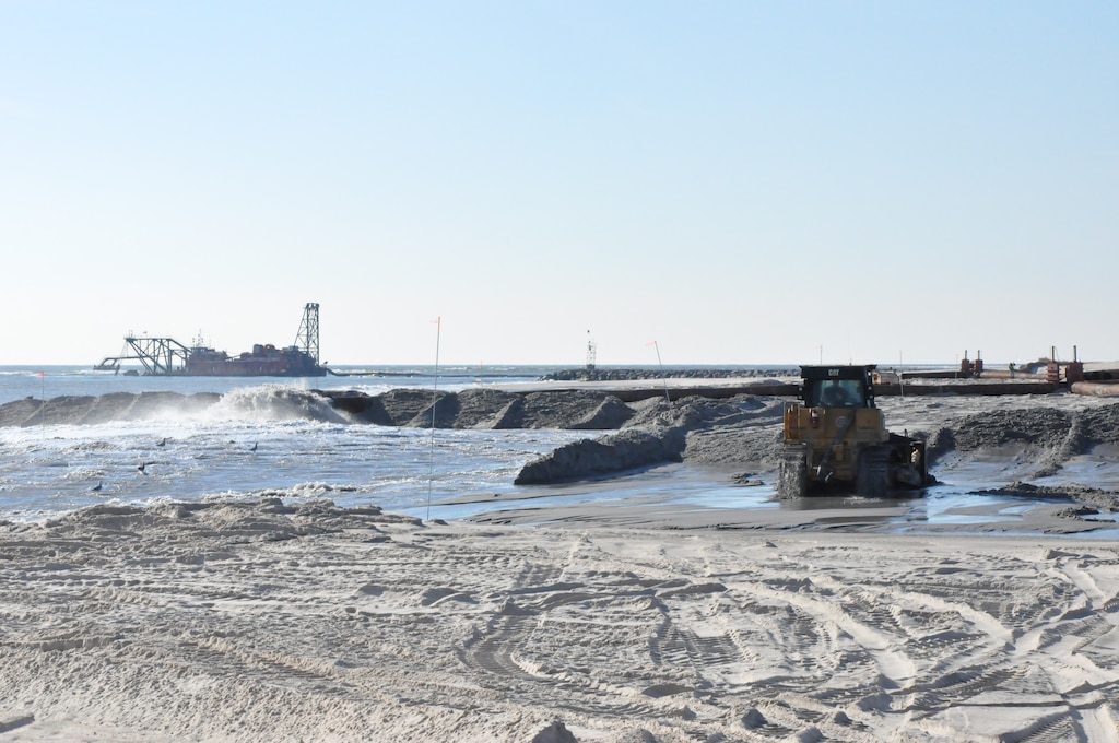 Crews work to move sand, freshly pumped from nearby Moriches Inlet, as part of post-Hurricane Sandy barrier island breach closure operations Monday November 26, 2012. The barrier island breach closure work at Cupsogue County Park, which was carried out as part of the Breach Contingency Plan in partnership with the New York State Department of Environmental Conservation, was completed Tuesday evening November 27, 2012. (photo by Chris Gardner, New York District public affairs)