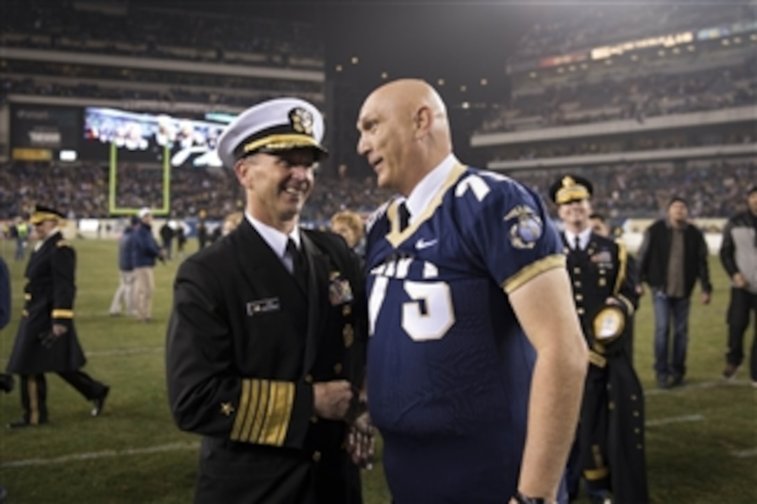 Chief of Naval Operations Adm. Jonathan Greenert shakes hands with Army Chief of Staff Gen. Ray Odierno as he wears a Naval Academy football jersey after Army lost the 113th Army-Navy football game at Lincoln Financial Field in Philadelphia, Pa., on Dec. 8, 2012.  The U.S. Naval Academy Midshipmen earned a close win over the U.S. Military Academy Cadets with a touchdown in the 4th quarter to edge Army 17-13.  