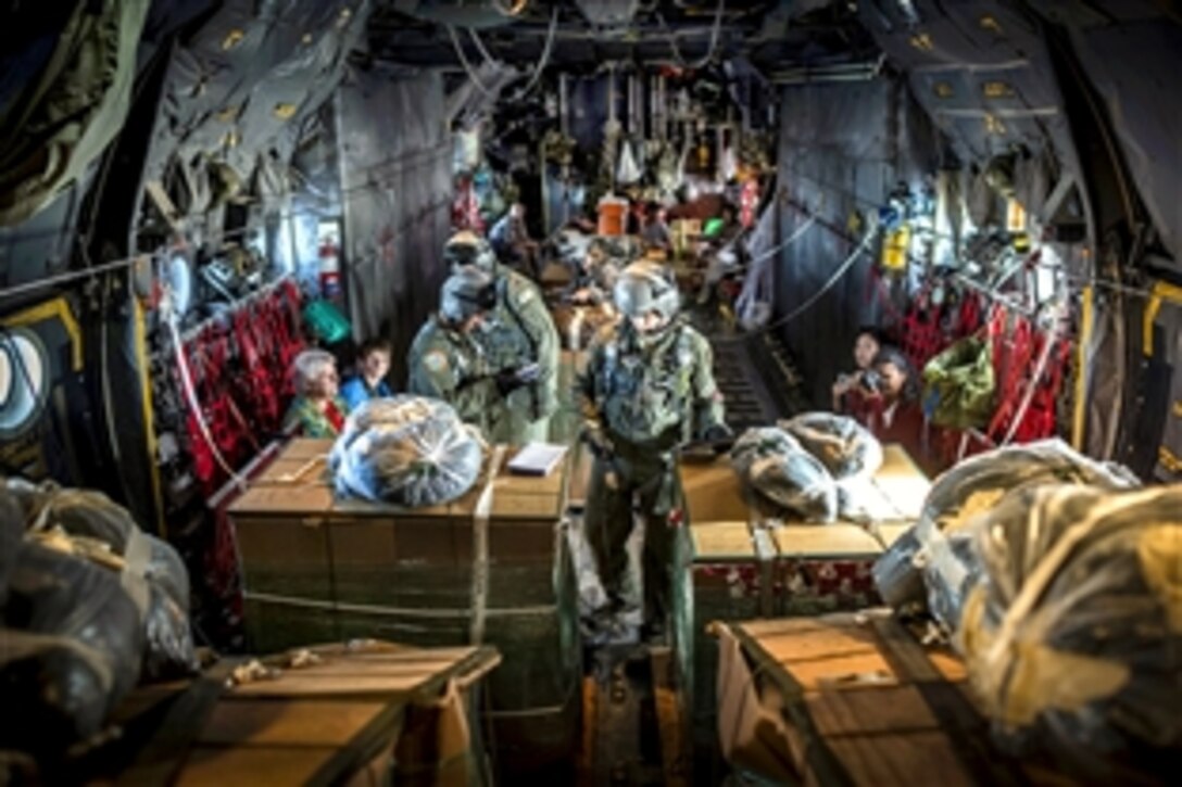 U.S. Air Force loadmasters inside a C-130H aircraft prepare humanitarian goods destined for remote islands within the Micronesian Islands during the 61st anniversary of Operation Christmas Drop, Dec. 11, 2012. The loadmasters, are assigned to the 36th Airlift Squadron, Yokota Air Base, Japan. 