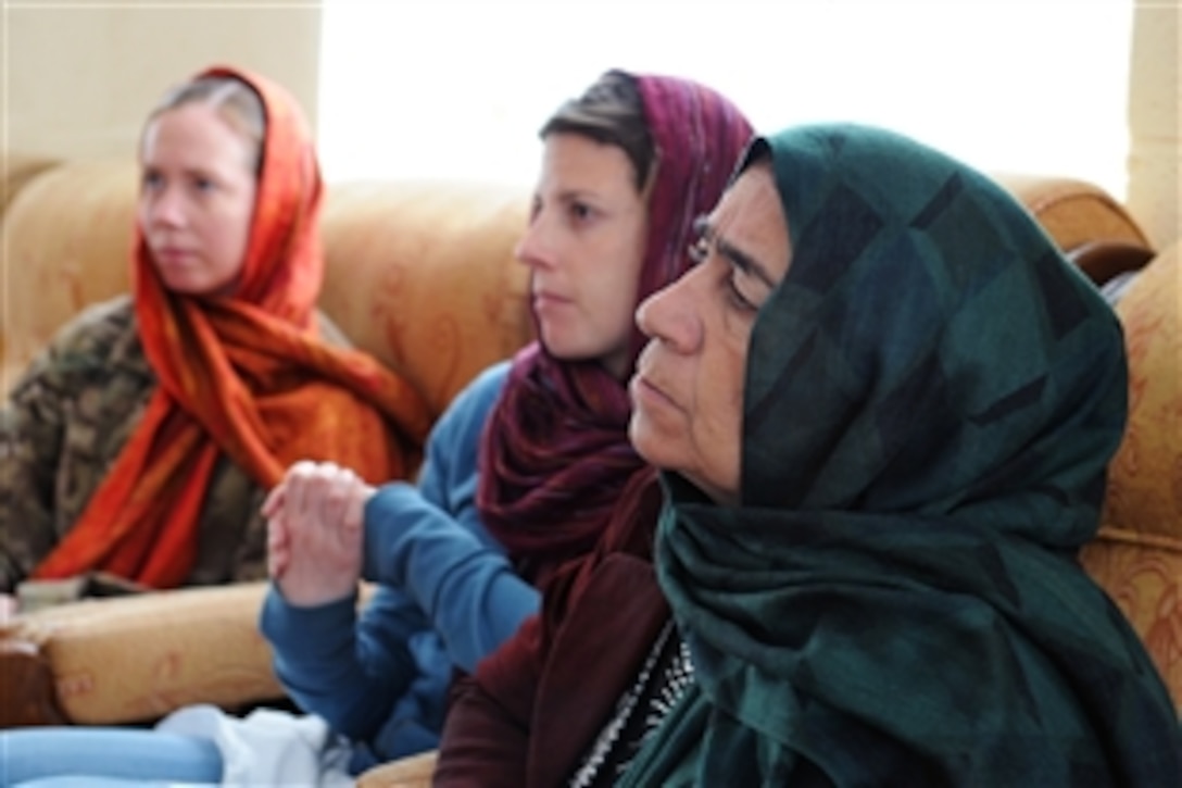 A U.S. service member, left, a U.S. civilian, center, and an Afghan woman who serves on the Farah Provincial Council, right, take part in a senior meeting on women's issues in Farah, Afghanistan, Dec. 6, 2012. The soldier is assigned to the Provincial Reconstruction Team Farah. The women's shura was held in conjunction with the 16-Day Campaign to End Violence Against Women. 
