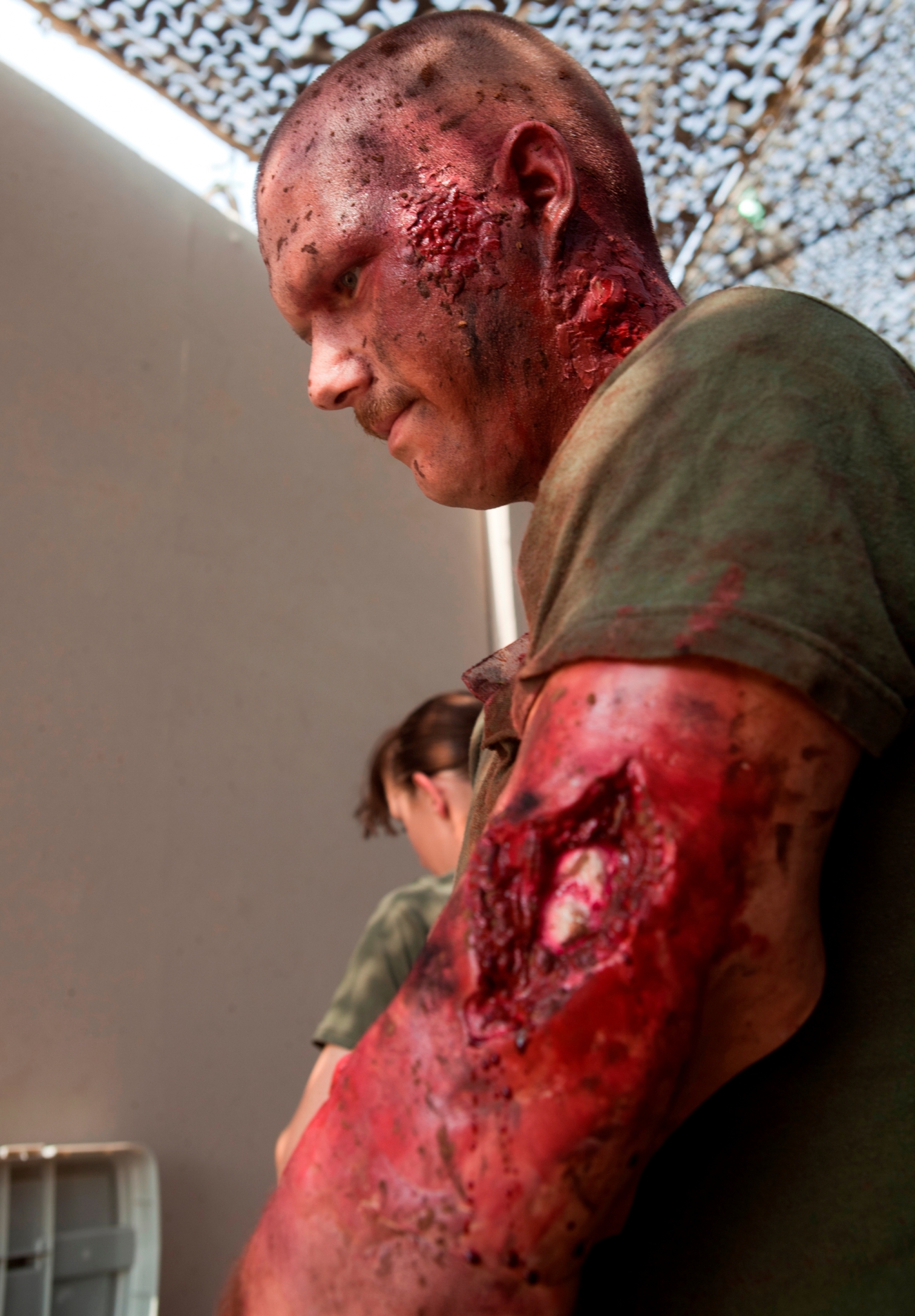 Thanks to the magic of makeup, Navy Corpsman, HN1 (FMF) Edward Palakie, with Marine Aircraft Group 40 is ready to simulate a casualty in a trauma response exercise. MAG-40 currently assigned to U.S. Marine Corps Forces Central Command engages in Theater Security Cooperation activities throughout the U.S. Central Command area of responsibility and is prepared to provide rapid reaction to emerging crisis and contingency operations. (U.S. Marine photo by Sgt. Leon M. Branchaud)