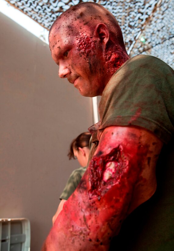 Thanks to the magic of makeup, Navy Corpsman, HN1 (FMF) Edward Palakie, with Marine Aircraft Group 40 is ready to simulate a casualty in a trauma response exercise. MAG-40 currently assigned to U.S. Marine Corps Forces Central Command engages in Theater Security Cooperation activities throughout the U.S. Central Command area of responsibility and is prepared to provide rapid reaction to emerging crisis and contingency operations. (U.S. Marine photo by Sgt. Leon M. Branchaud)