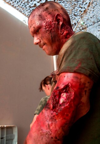 Thanks to the magic of makeup, Navy Corpsman, HN1 (FMF) Edward Palakie, with Marine Aircraft Group 40 is ready to simulate a casualty in a trauma response exercise. MAG-40 currently assigned to U.S. Marine Corps Forces Central Command engages in Theater Security Cooperation activities throughout the U.S. Central Command area of responsibility and is prepared to provide rapid reaction to emerging crisis and contingency operations. (U.S. Marine photo by Sgt. Leon M. Branchaud)
