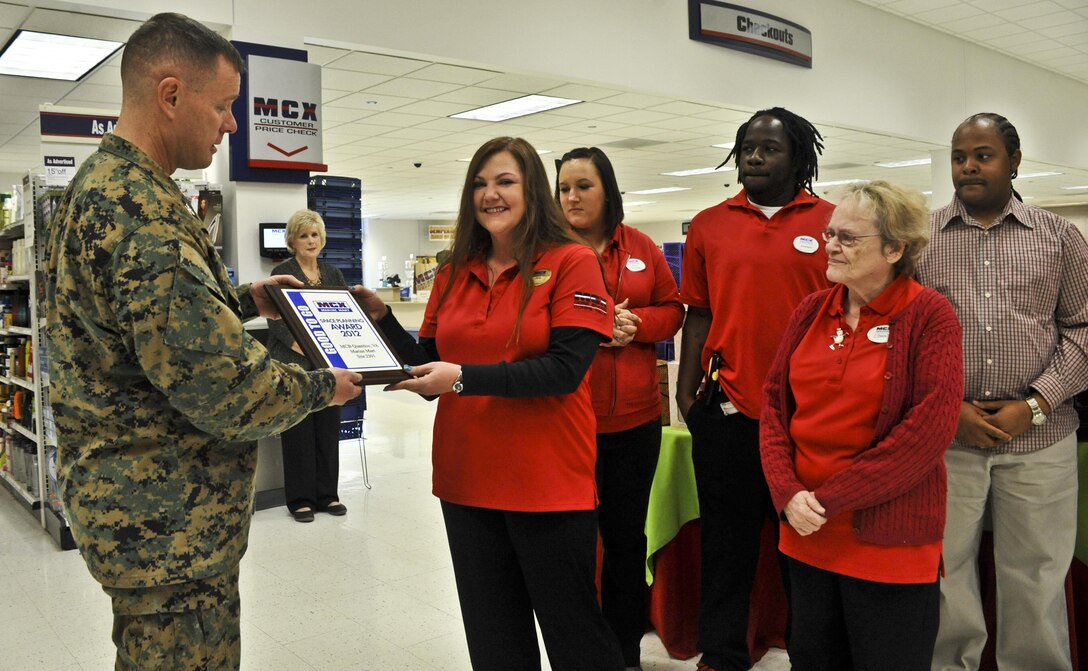 Col. David W. Maxwell, base commander, presents the staff of the Marine Corps Exchange Marine Mart  on Barnett Avenue, with the MCX Space Panning Award, at the main exchange on Dec. 5. Sgt. Maj. Laura Brown, base sergeant major, also attended the presentation. 