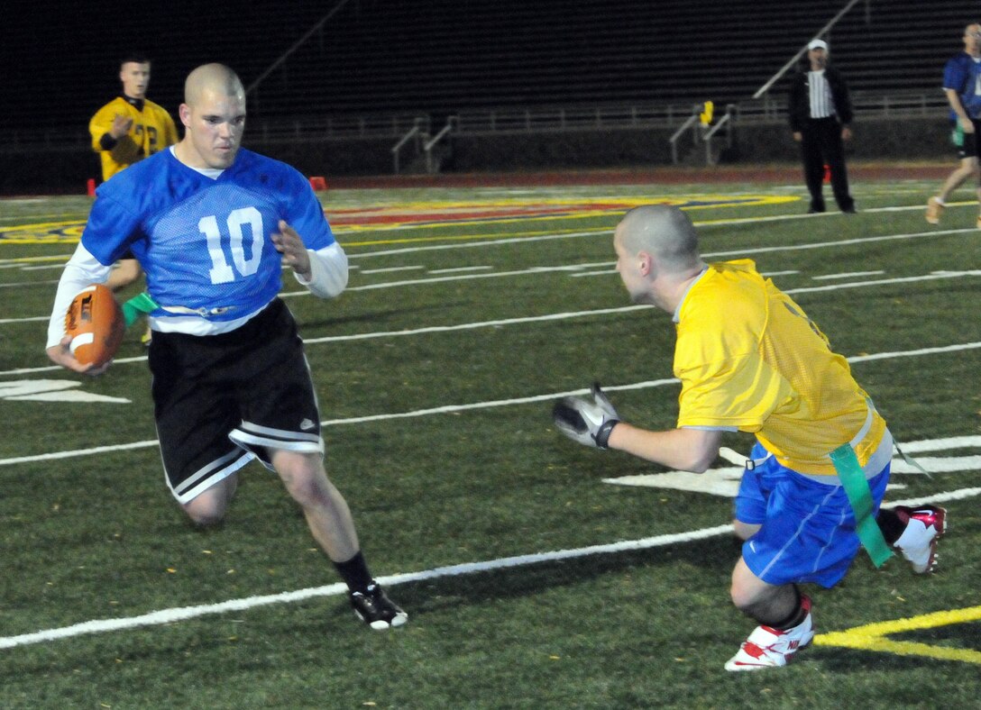 Jarrett Hawkins, a player for Marine Helicopter Squadron-1’s American League intramural flag football team, jukes to his right to evade a Headquarters and Service Battalion player during the first round of the playoffs at Butler Stadium on Dec. 3. HMX-1 defeated H&SBn., 18 – 0.