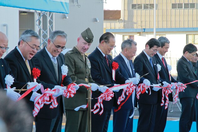 Col. James C. Stewart, Marine Corps Air Station Iwakuni commanding officer, stands next to distinguished guests at the tape cutting ceremony for the Iwakuni Kintaikyo Airport Dec 9, 2012. Distinguished guests cut the tape and 1,000 civilians invited by the city of Iwakuni were given a pair of scissors to cut ribbon symbolizing the airport as a community asset.