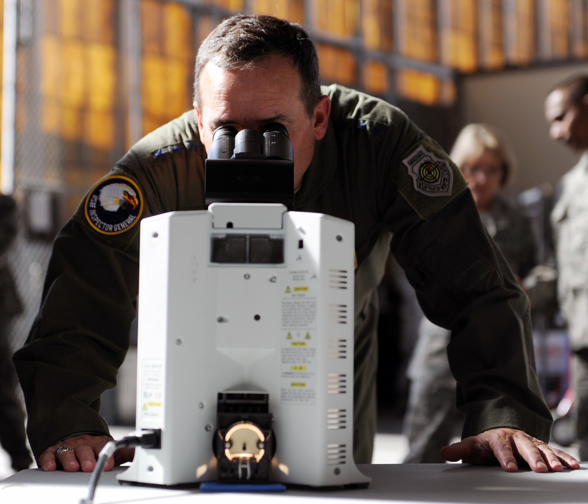 Lt. Gen. Stephen Mueller, Air Force Inspector General, is taught how to review a cell count under a microscope Dec. 12 during a tour of 15th Wing units at Joint Base Pearl Harbor-Hickam, Hawaii. Along with performing duties directed by the Air Force Secretary or the Chief of Staff, Mueller is responsible for two field operating agencies: the Air Force Inspection Agency and the Air Force Office of Special Investigations. The 15th Medical Group consists of a staff of over 250, operating on a $10-million budget and averages approximately 6,500outpatient visits, nearly 9,000 prescriptions, 3,000 Lab procedures, and 900 radiology films per month. (U.S. Air Force photo by Staff Sgt. Nathan Allen)