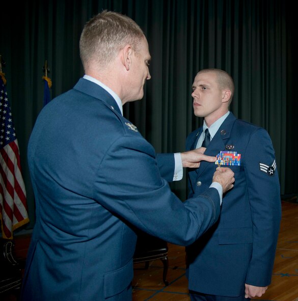 Col. Martin Chapin, 621st Contingencey Response Wing commander, pins a Purple Heart on Senior Airman Kevin Bolton, 573rd Global Support Squadron air transportation specialist Dec. 12 at the Travis Air Force Base theater. Bolton was deployed to Forward Operating Base Salerno, Afghanistan as part of the 60th Aerial Port Squadron. (U.S. Air Force photo/Airman 1st Class Nicole Leidholm)