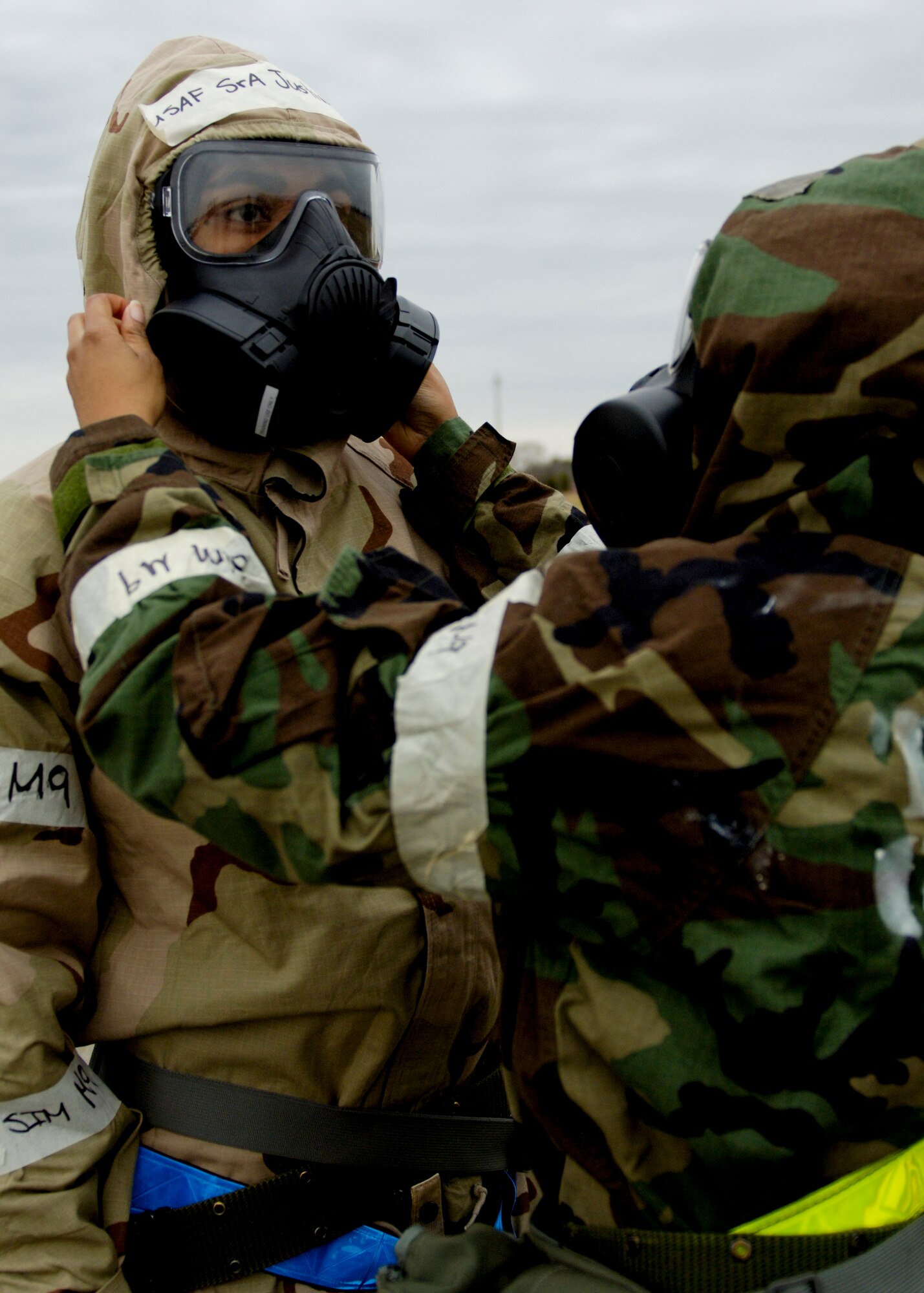 U.S. Air Force Senior Airman Sandra Askew, 633rd Surgical Squadron women’s health clinic, removes an Airman’s boot during a simulated chemical attack at Langley Air Force Base, Va., Dec. 12, 2012. During this phase I command unit exercise, players were instructed to break into pairs and assist each other through the simulated-chemical decontamination process stations. (U.S. Air Force photo by Airman Kimberly Nagle/Released)