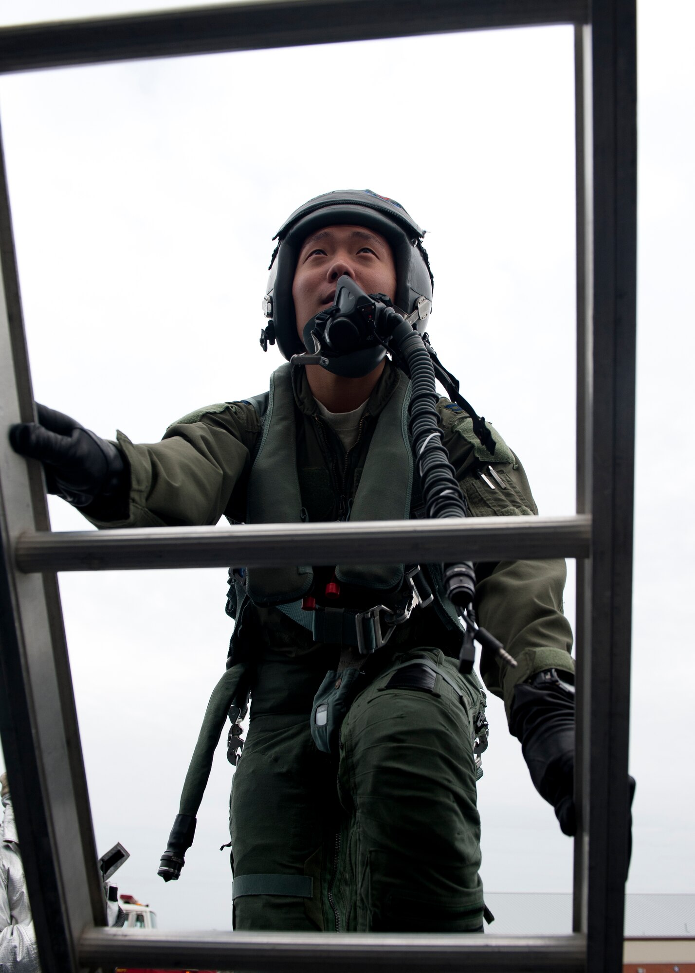 U.S. Air Force Capt. Jamie Mun, 94th Fighter Squadron pilot, ascends a ladder to enter an F-22A for an extraction inject during the phase I combined unit exercise at Langley Air Force Base, Va., Dec. 12, 2012.  The CUE was held to validate the full spectrum of Langley's deployment operations.  (U.S. Air Force photo by Staff Sgt. John D. Strong II/Released)