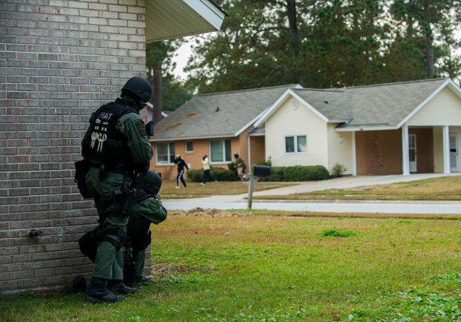 Two members of the Charleston County Sheriff’s Office Special Weapons and Tactics team observes “hostages” flee from a house Dec. 6, 2012, at Joint Base Charleston - Air Base, S.C. during a training exercise. The SWAT team provides a coordinated response to critical incidents throughout Charleston County, and whenever requested, in other areas throughout the state of South Carolina. (U.S. Air Force photo/ Airman 1st Class George Goslin)