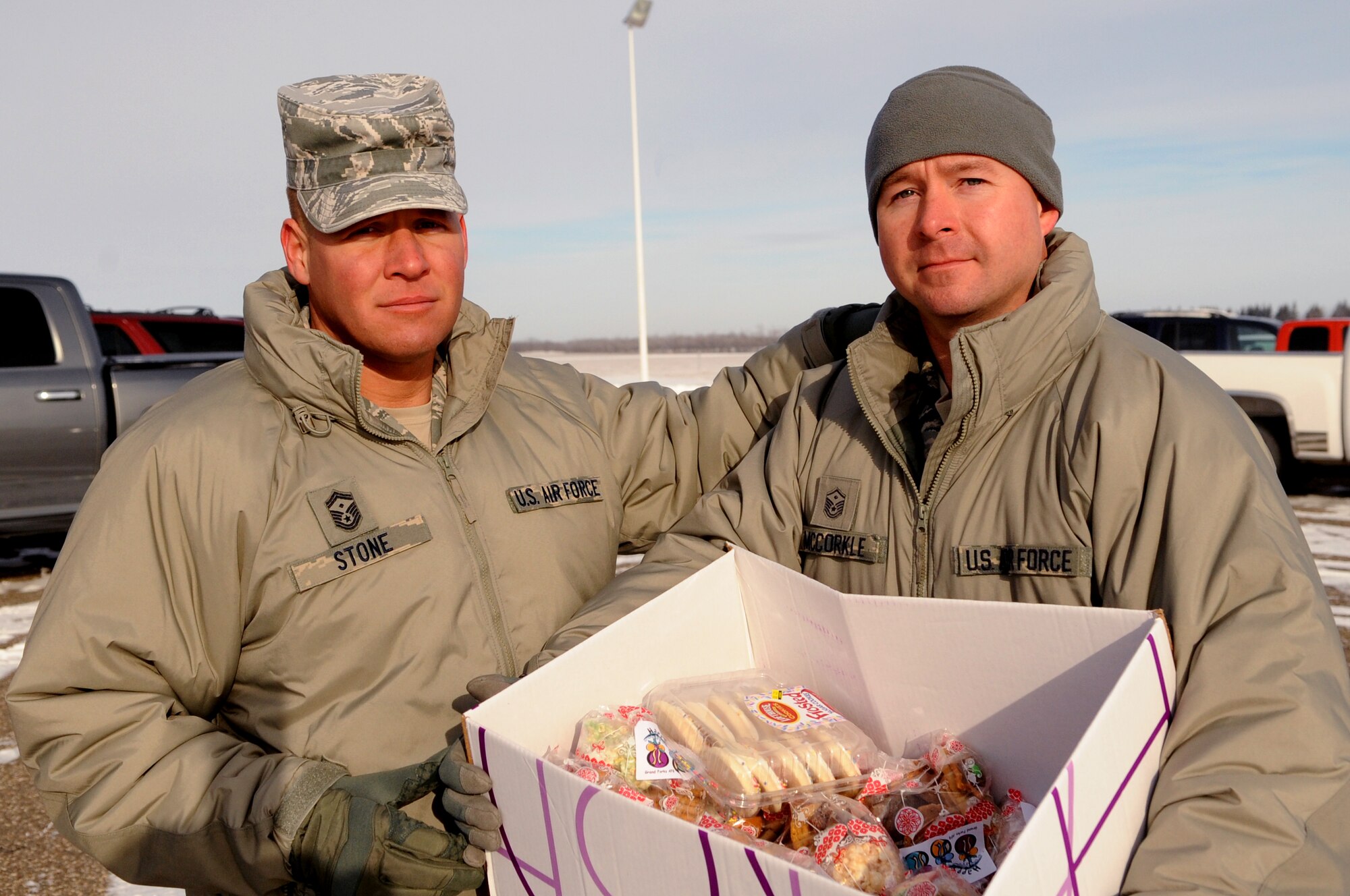 Senior Master Sgt. Brian Stone, 69th Reconnaissance Group first sergeant, and Master Sgt. Richard McCorkle, 319th Operations Support Squadron first sergeant, pose with a full box of cookie bags to deliver to Airmen currently working at Cavalier Air Station, N.D., on Dec. 10, 2012. Every year, the Grand Forks Air Force Base Spouses’ Club shows their appreciation by baking cookies and assembling cookie bags to surprise Airmen who live in the dorms. This year, the Grand Forks Air Force Base First Sergeants’ Council delivered cookies to Airmen stationed on Cavalier Air Force Station and Grand AFB, N.D. (U.S. Air Force photo/Staff Sgt. Amanda N. Grabiec)