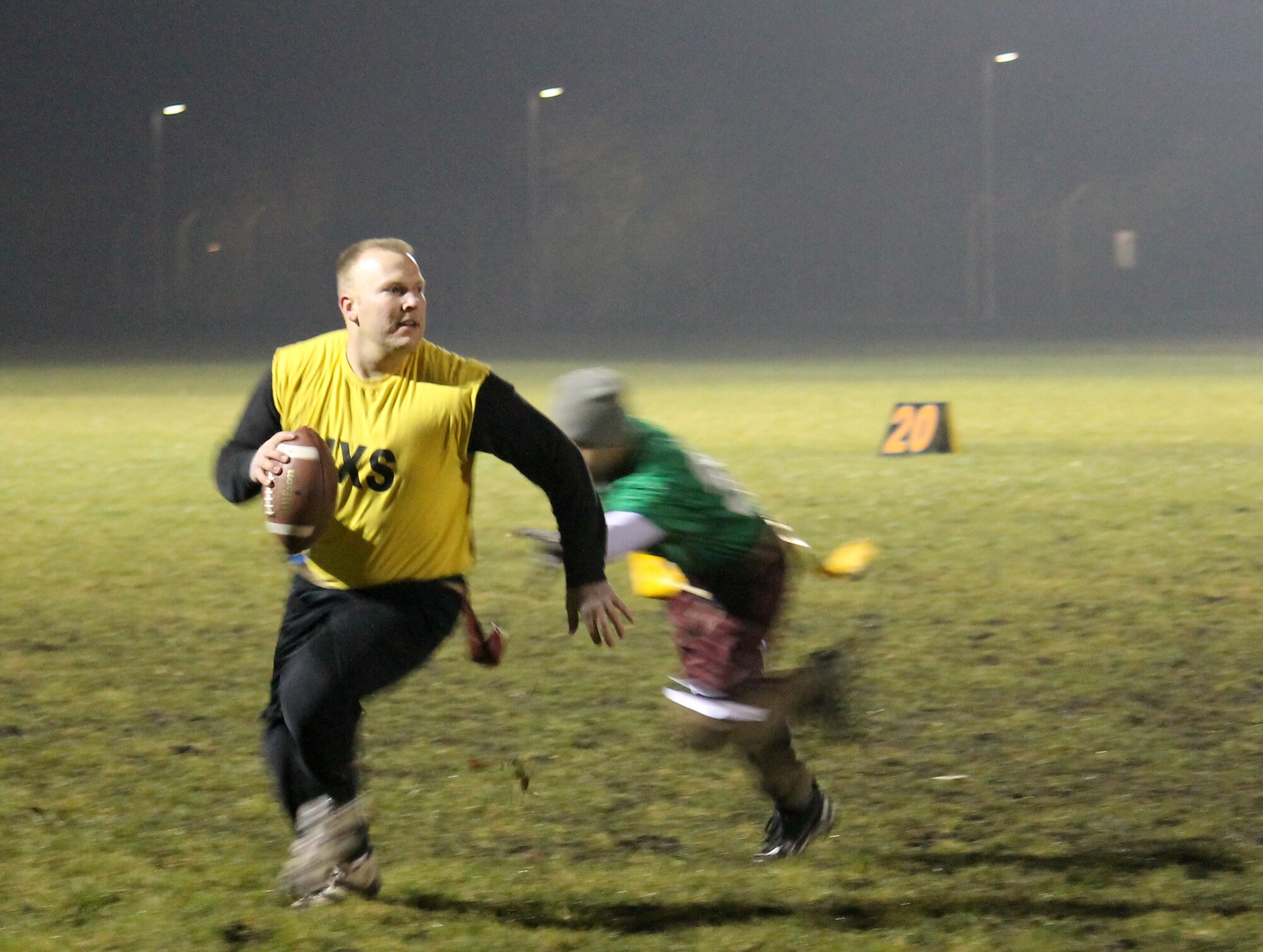 Staff Sgt. Brian Szarek, 100th Maintenance Group team quarterback, avoids a tackle during the RAF Mildenhall flag football championship game Dec. 12, 2012, at RAF Mildenhall, England. Maintenance defeated the 100th Communications Squadron/Force Support Squadron team by a final score of 14-12. (U.S. Air Force photo by Capt. Jason Smith/Released)